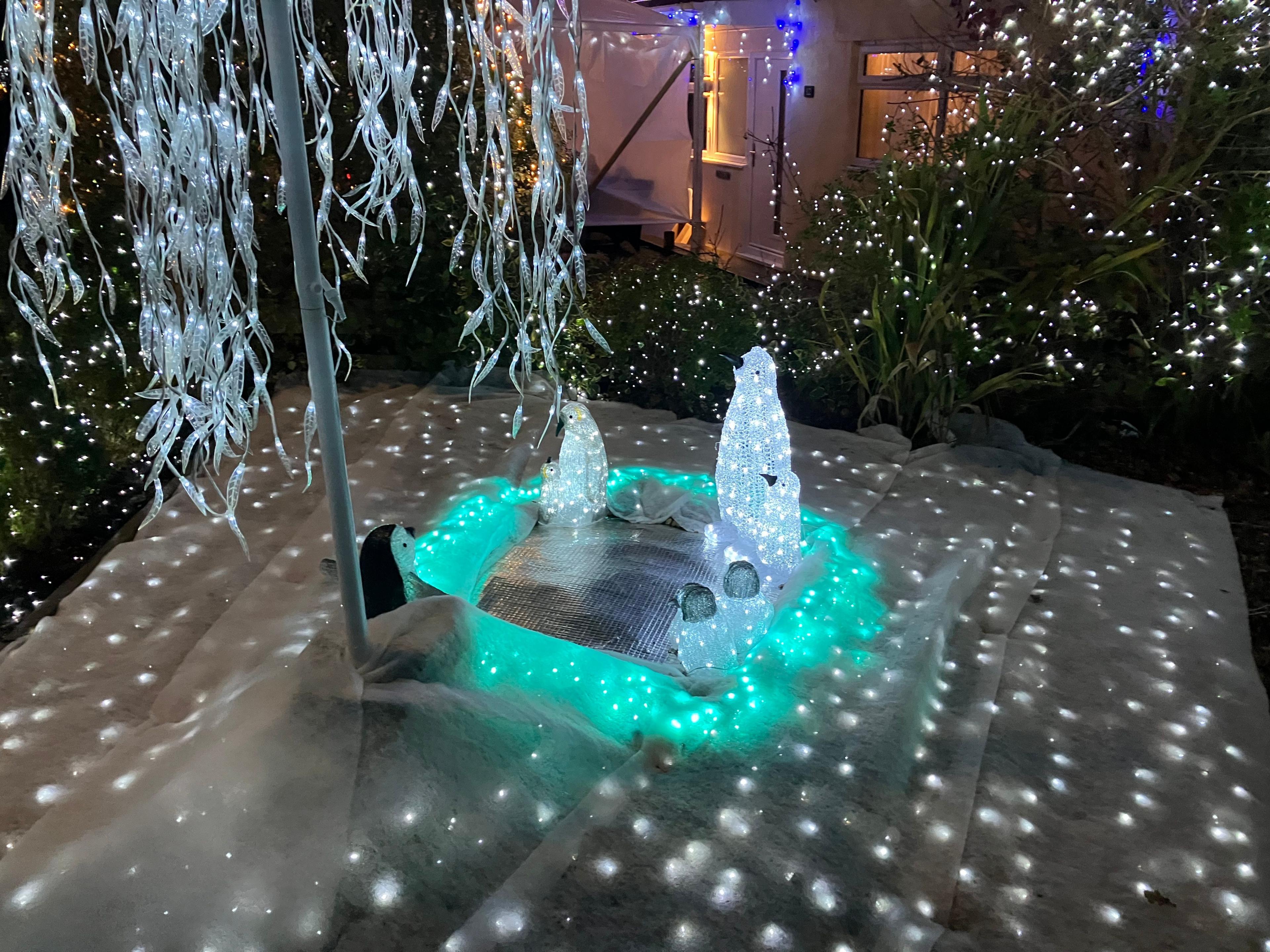 Penguin lights and fake snow on lawn