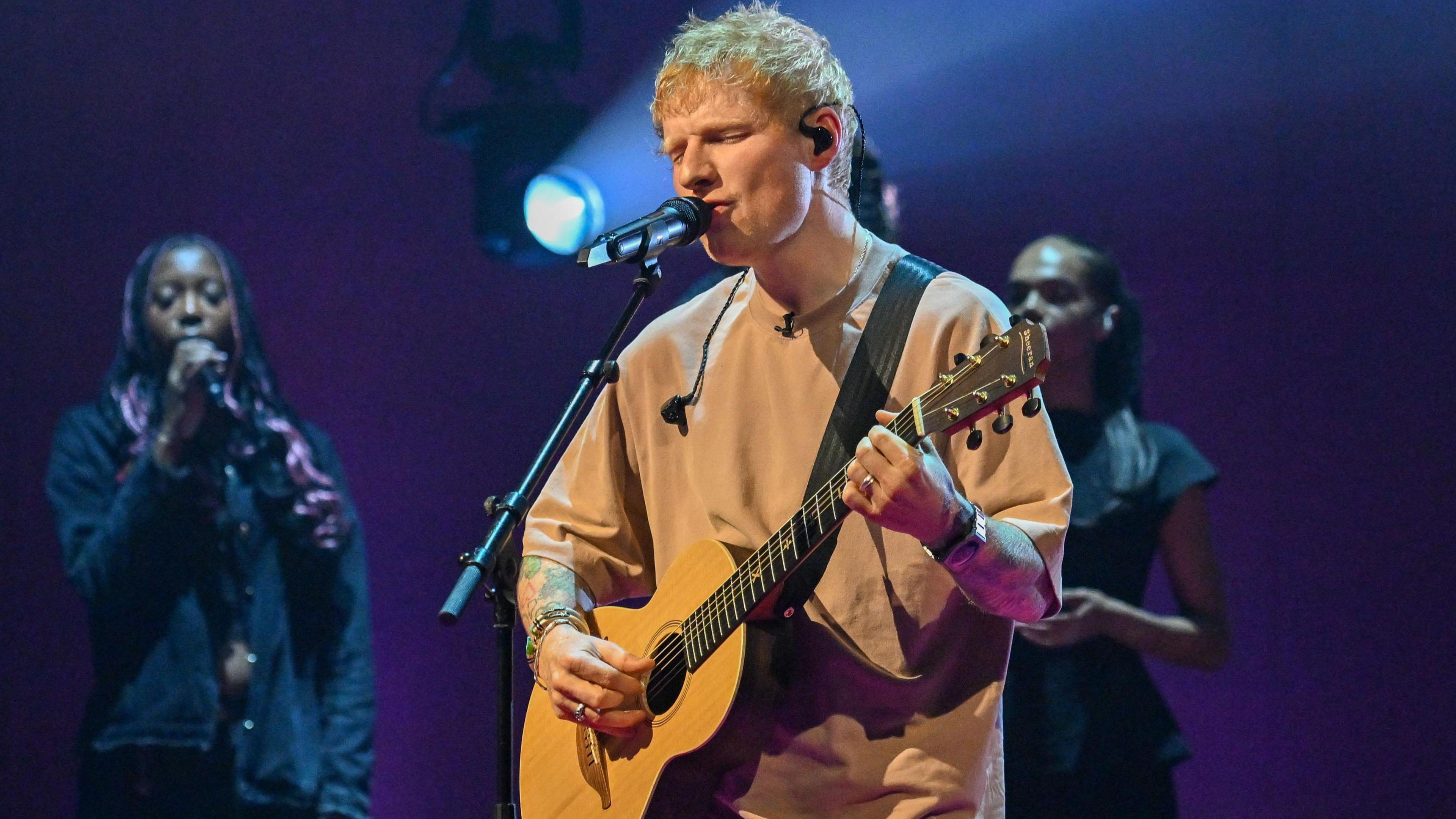 Ed Sheeran performs during filming for the Graham Norton Show in November 2025, singing and playing a guitar