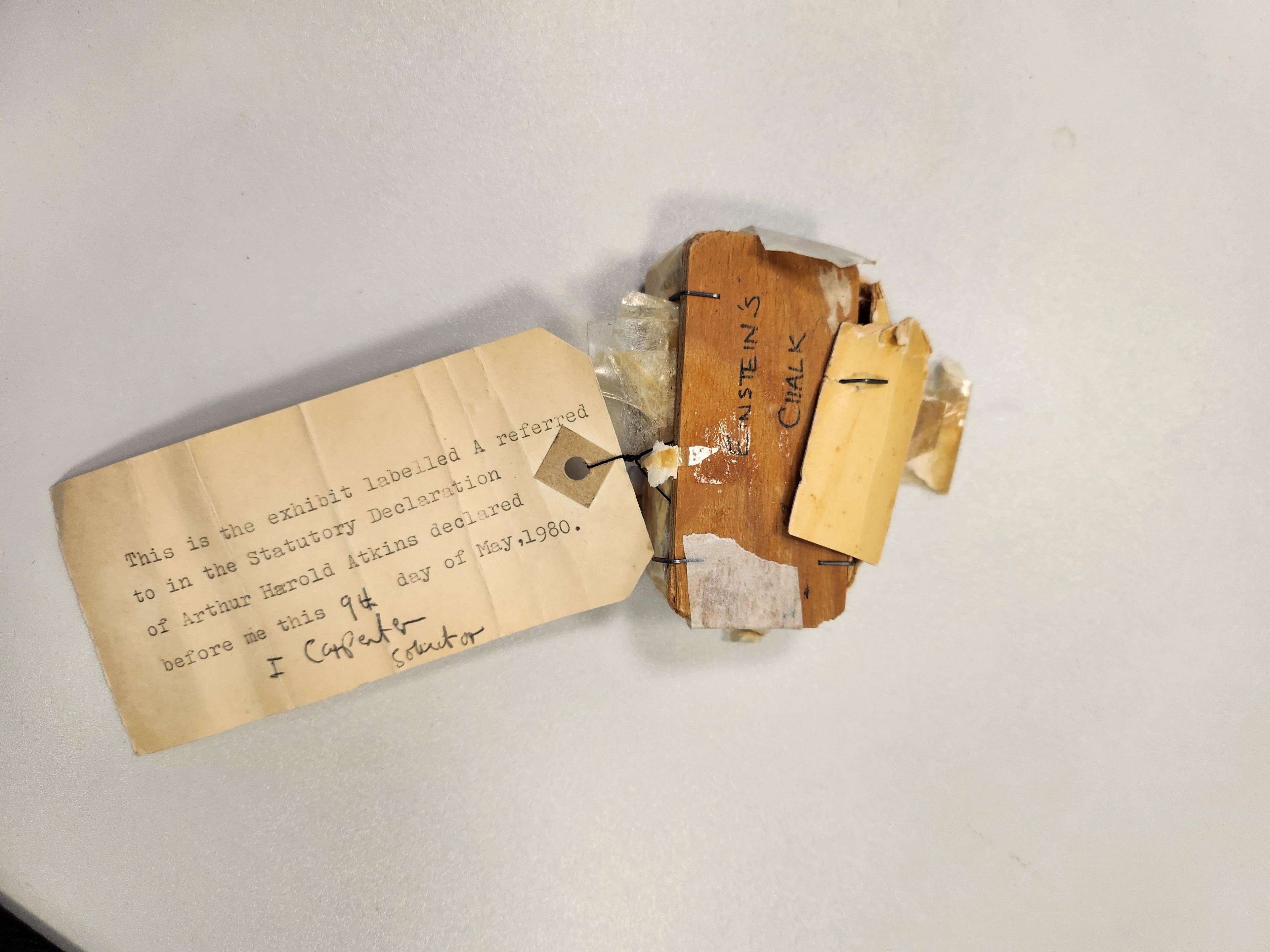 A piece of chalk is wrapped with a label attached