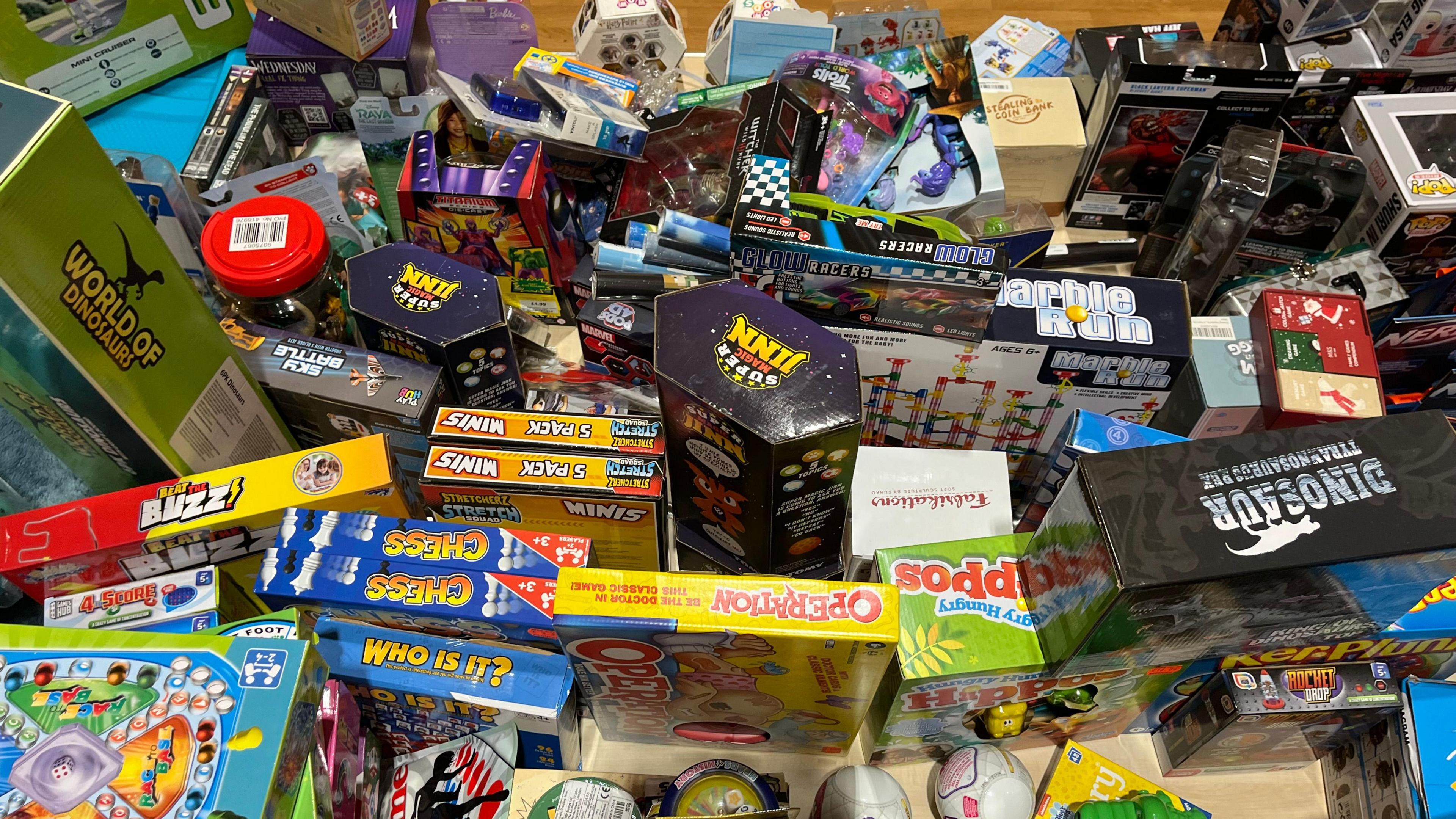 A large collection of toys in boxes, including board games.