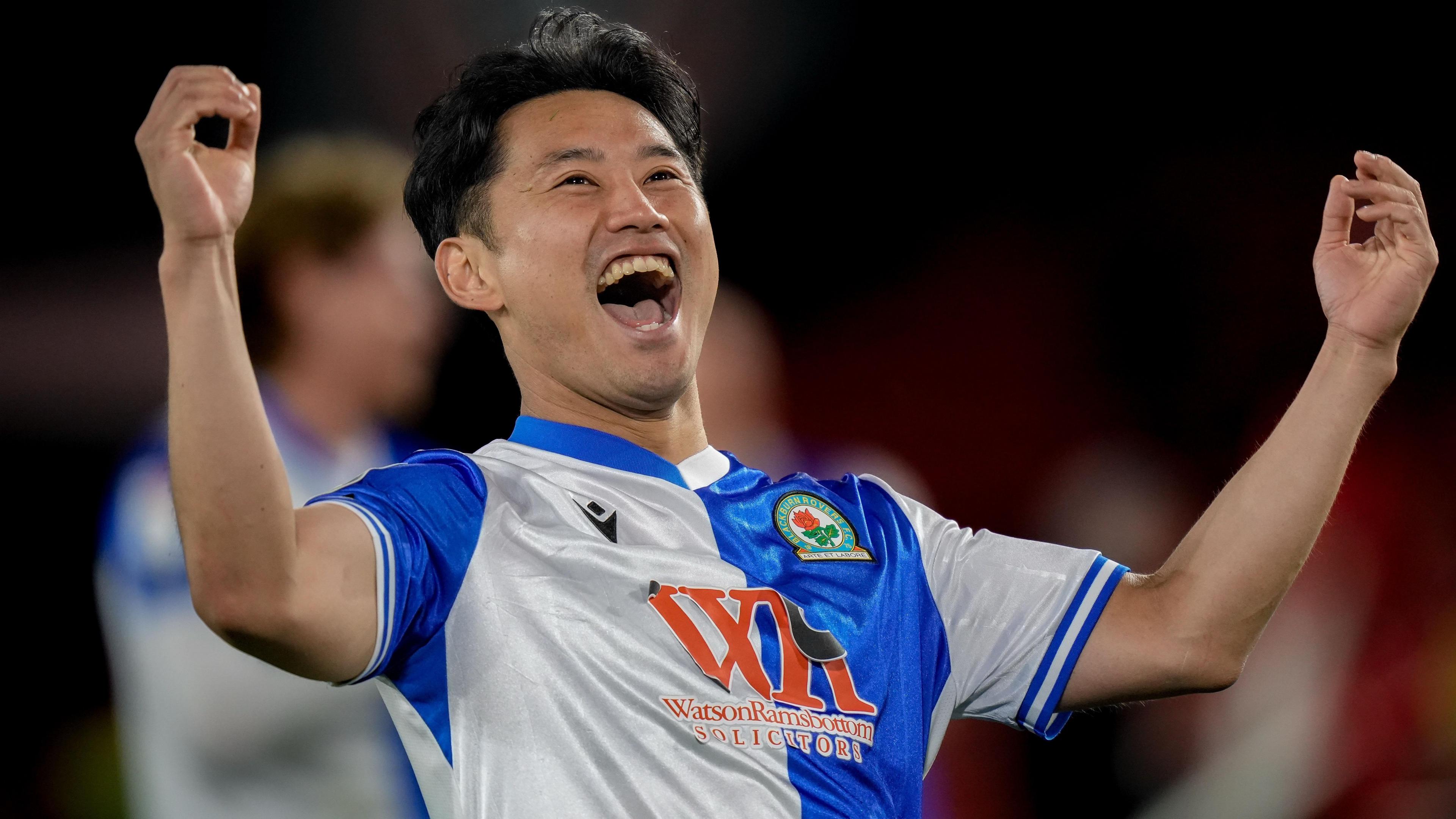 Ryoya Morishita, wearing Blackburn's blue and white home shirt, celebrates with his arms out by his side and hands raised with his mouth wide open while shouting towards the visiting Rovers fans after the win at Sheffield United.