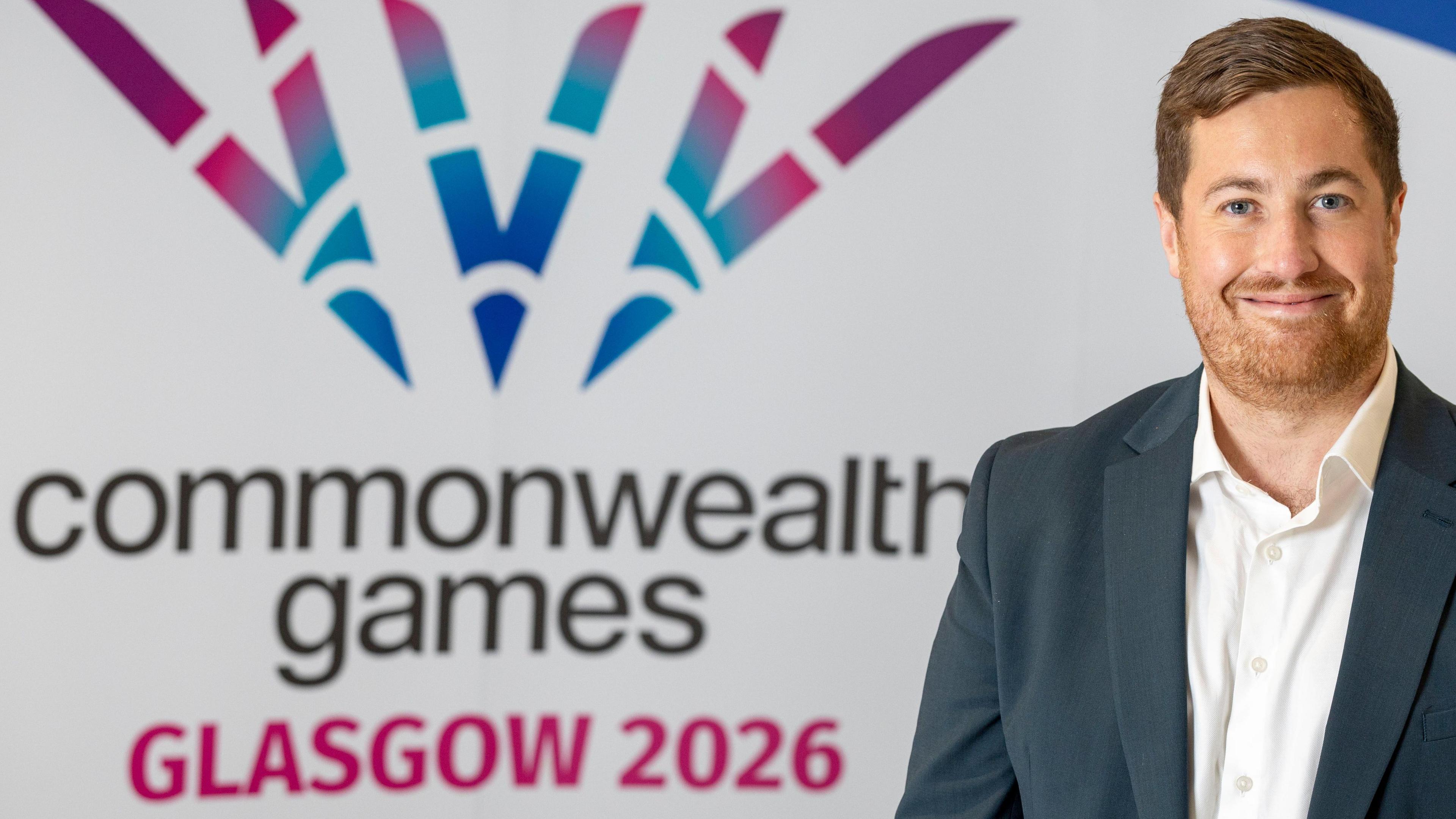 Phil Batty in front of a Commonwealth Games logo