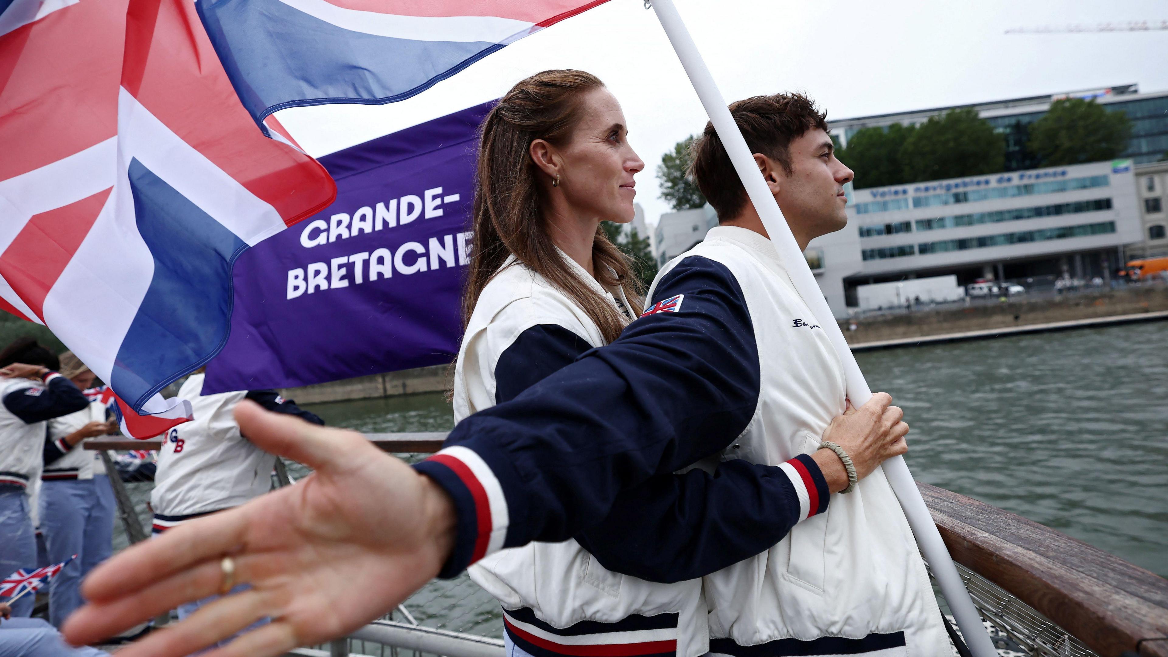 Olympic flag carriers Tom Daley and Helen Glover stand at the front of the Team GB boat