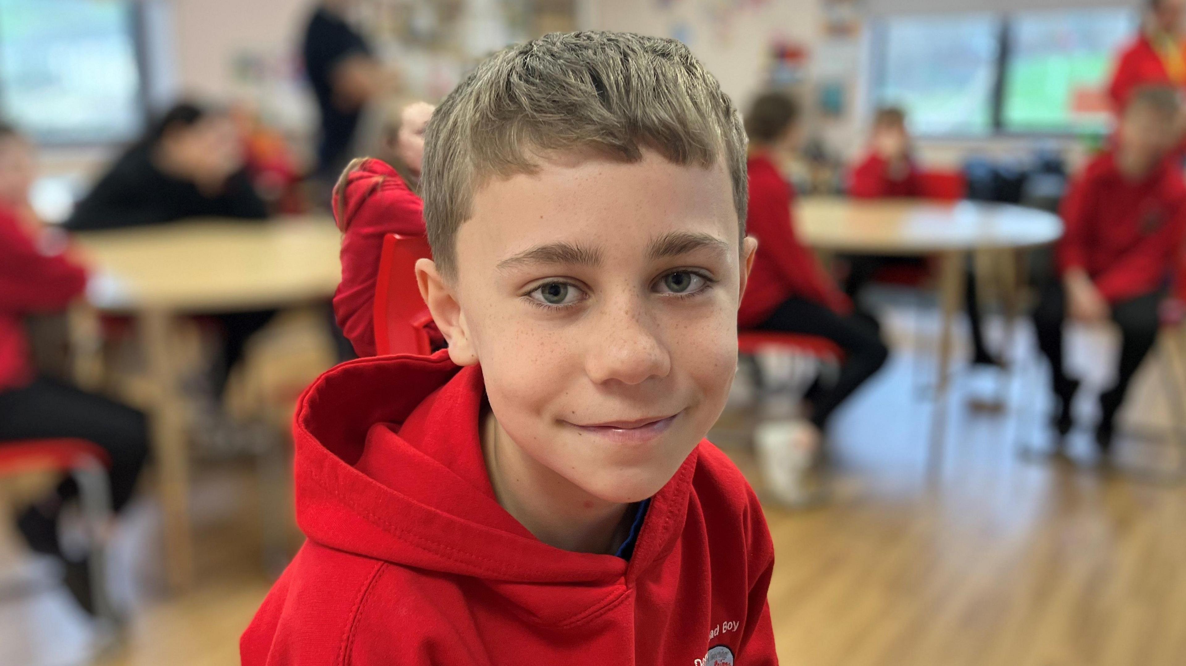 A boy in a classroom smiling