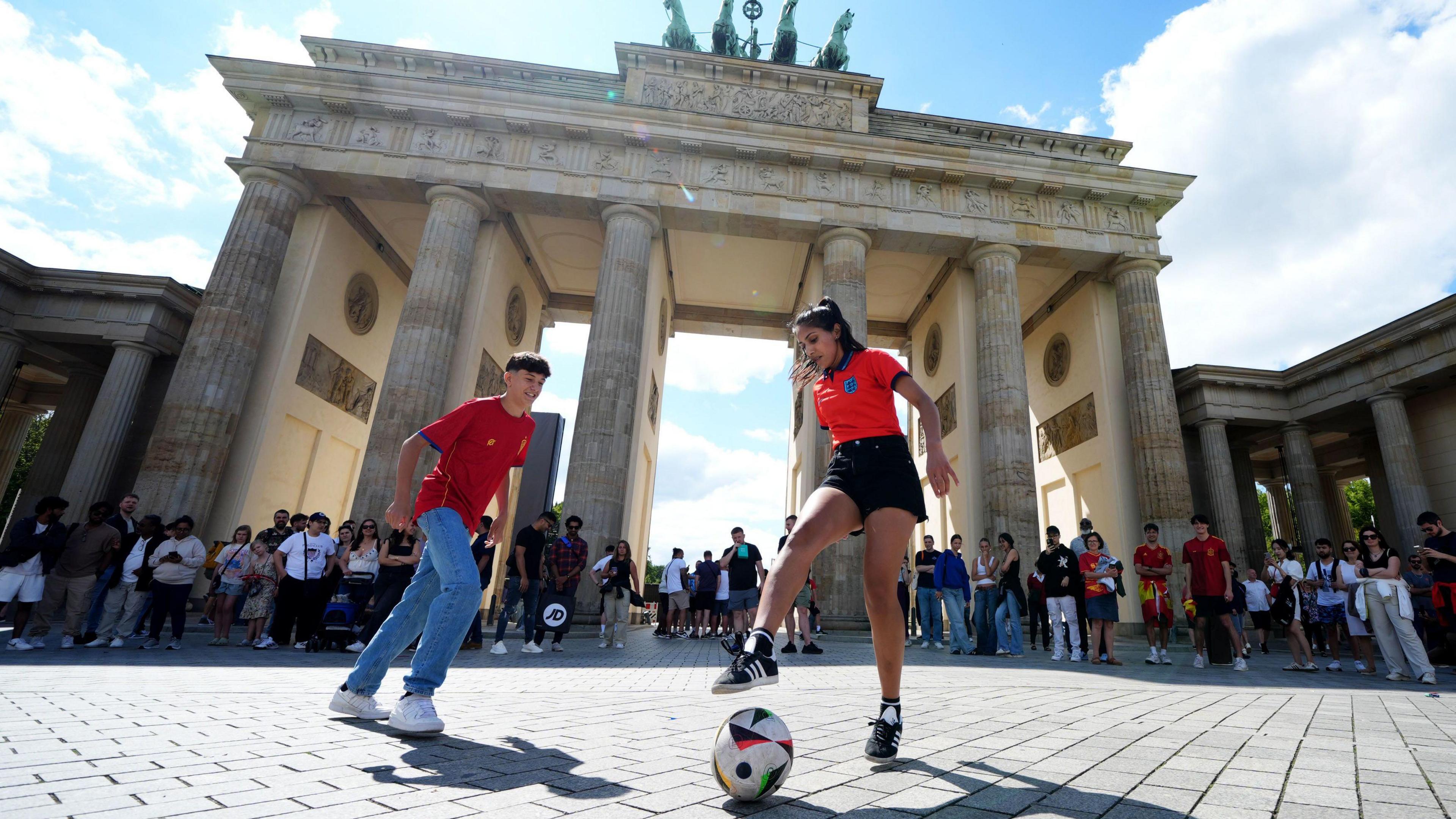 English fan plays football with a Spanish fan in Berlin