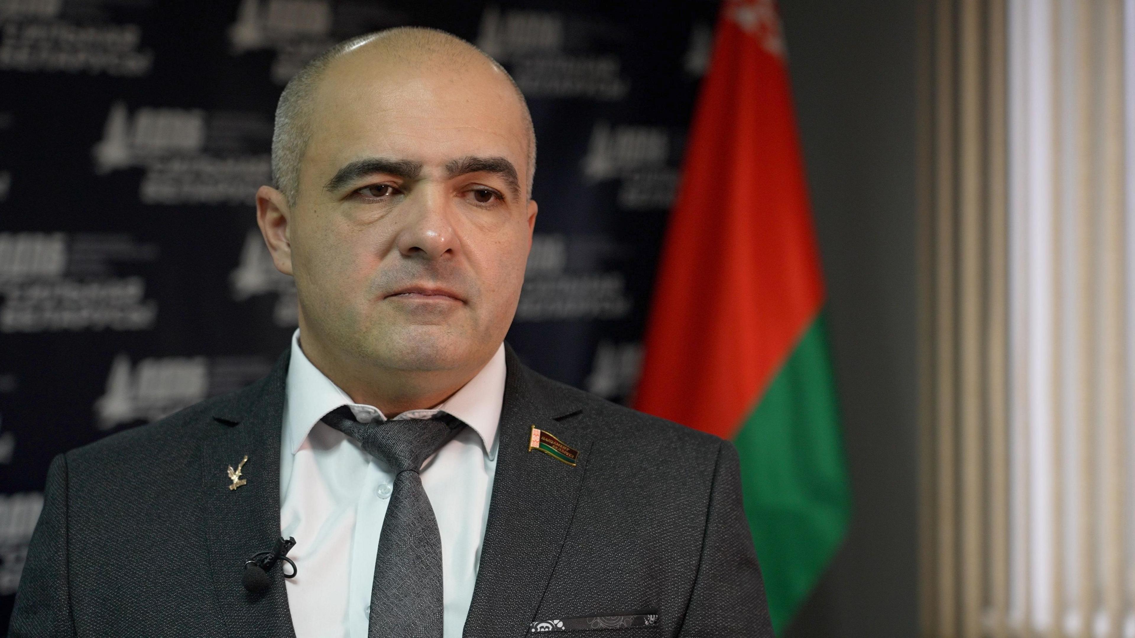 Oleg Gaidukevich, leader of the right-wing Liberal-Democratic Party, sits in front of the Belarusian flag