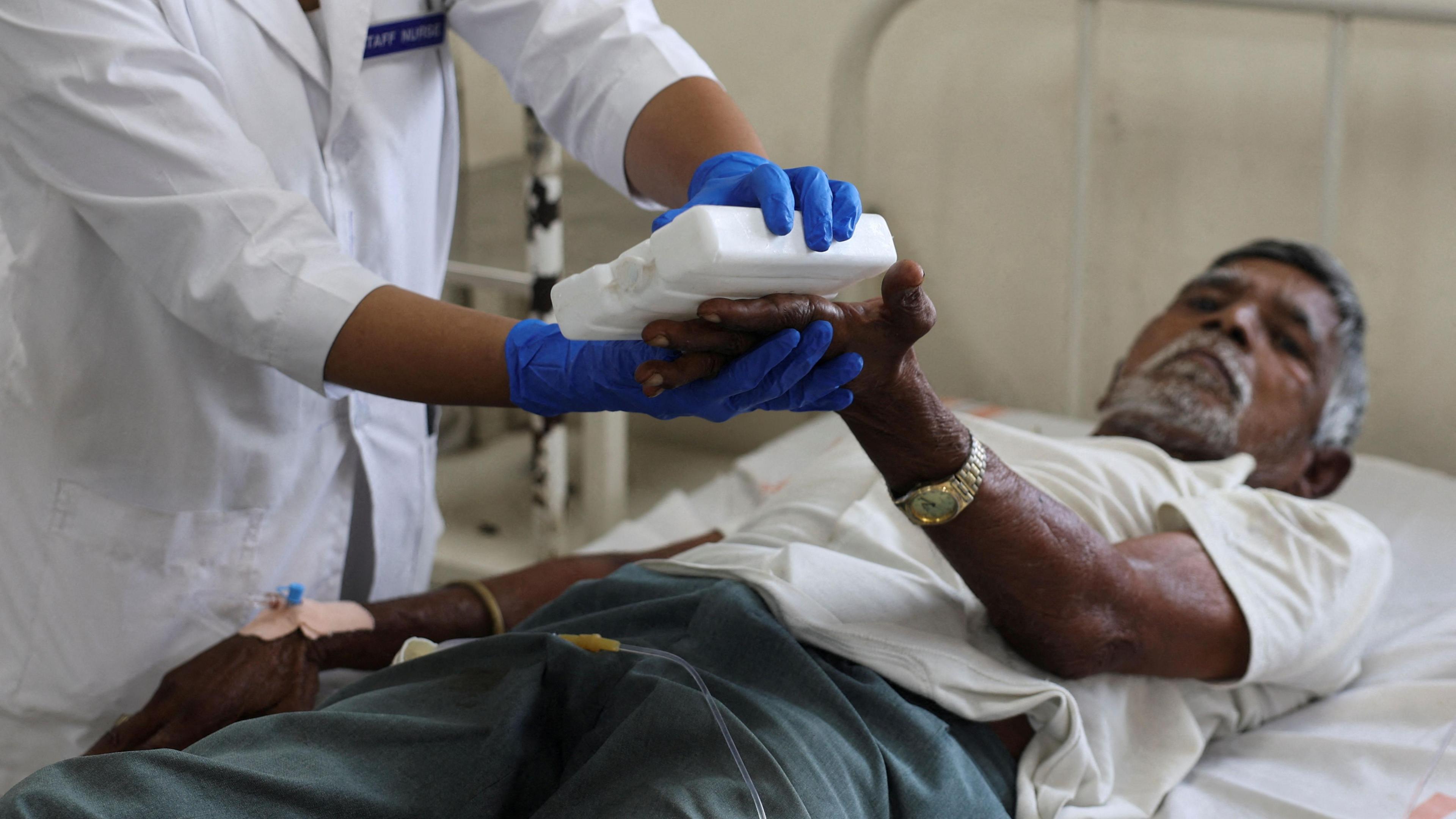 A nurse gives treatment to Dayabhai Parmar a 76-year-old patient of heat exhaustion inside a Heat Illness ward of a government hospital during a heatwave in Ahmedabad, India, May 25, 2024. REUTERS/Amit Dave