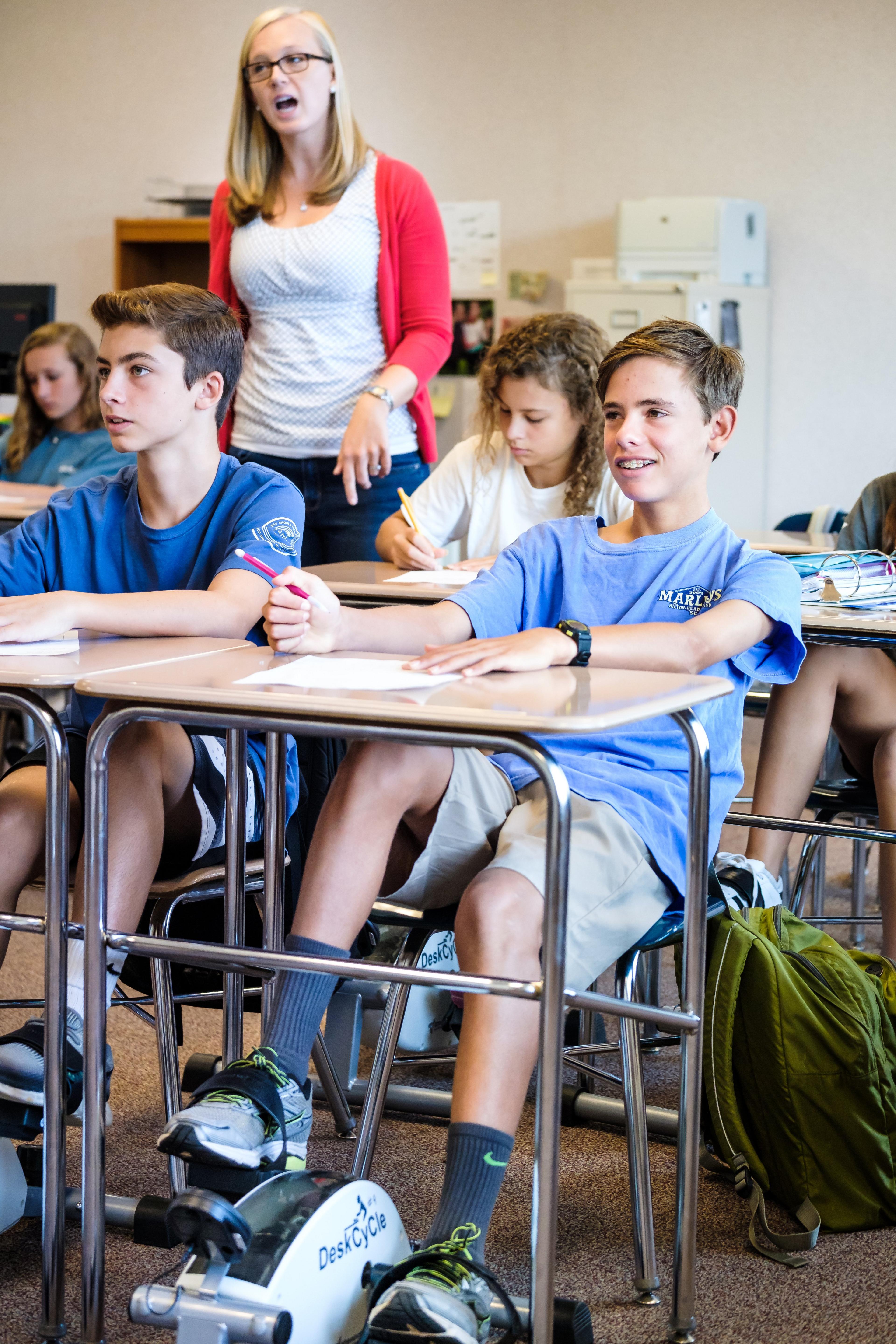 Teacher in class with pupils using pedals under desks