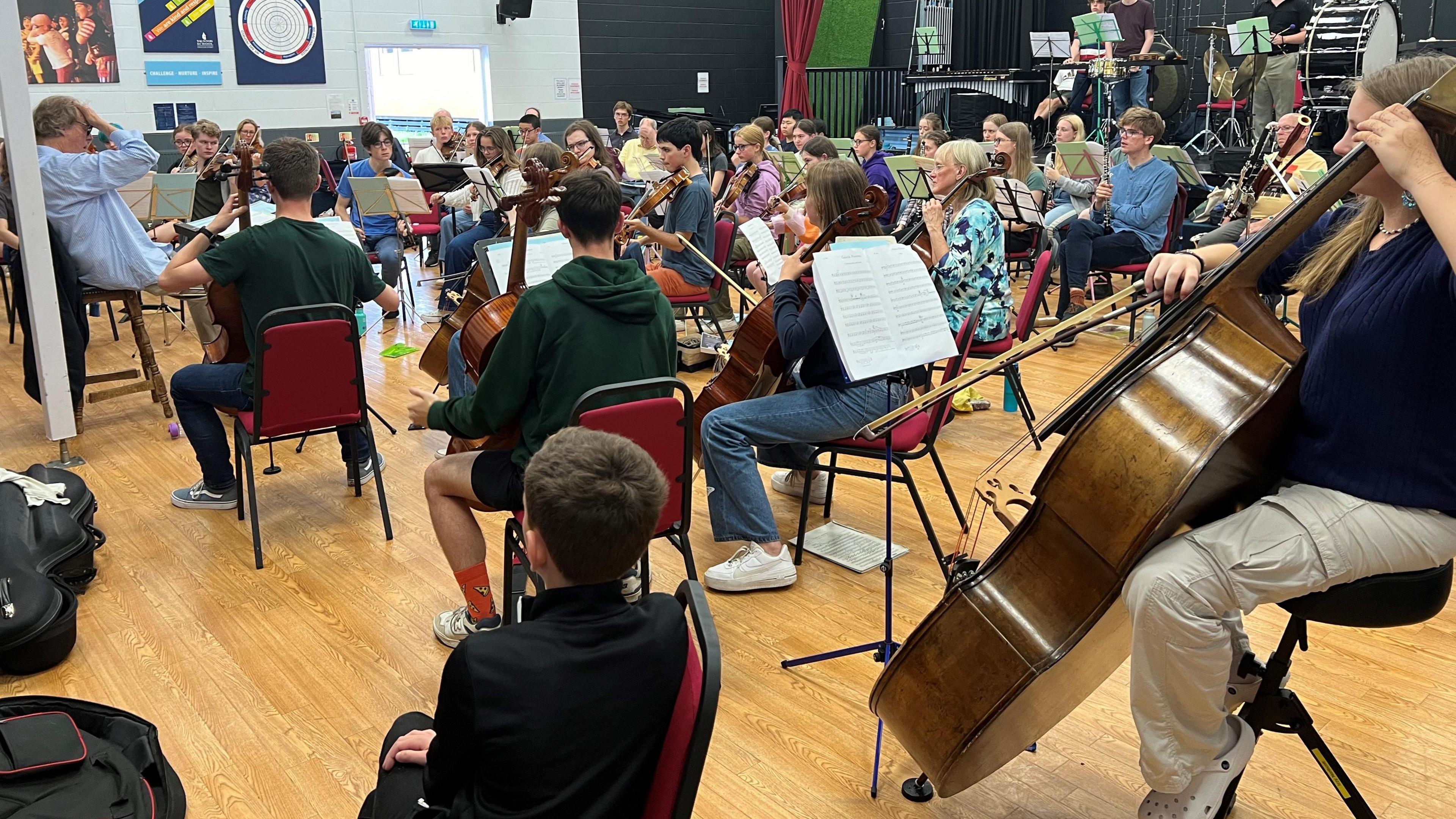 An orchestra rehearsing with their instruments