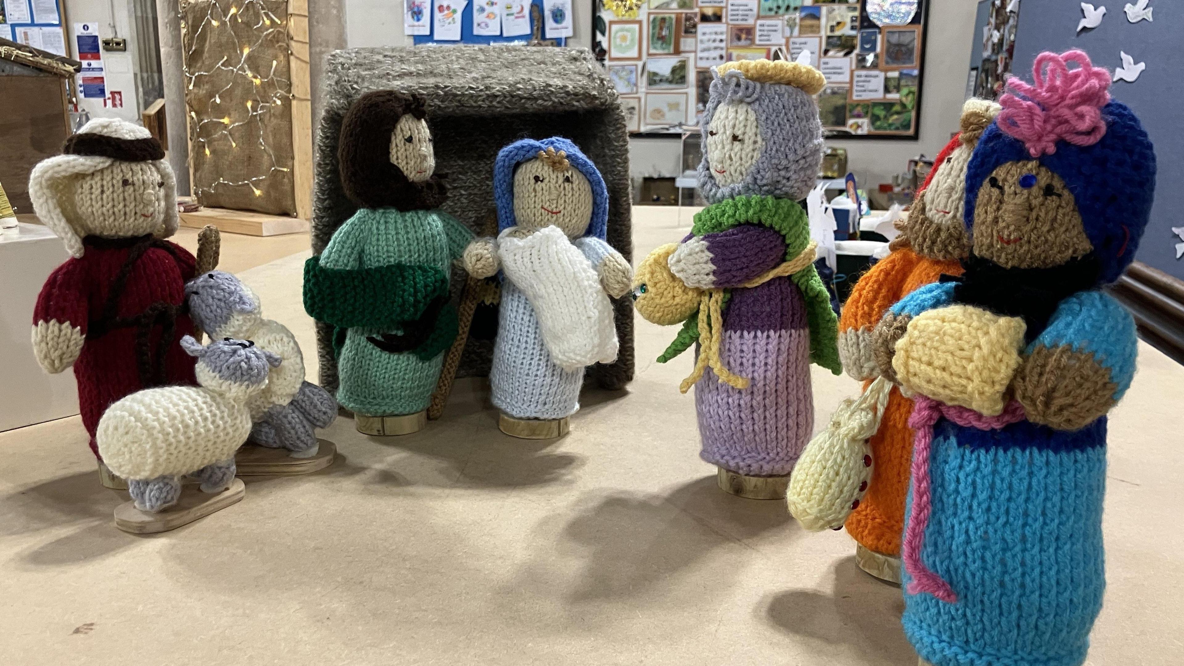 A group of knitted figures are seen displayed on a table at a church in Wickwar near Bristol as part of an event called Cribfest. The figures include the three wise men, Mary and Joseph and the baby Jesus and a shepherd with a pair of sheep