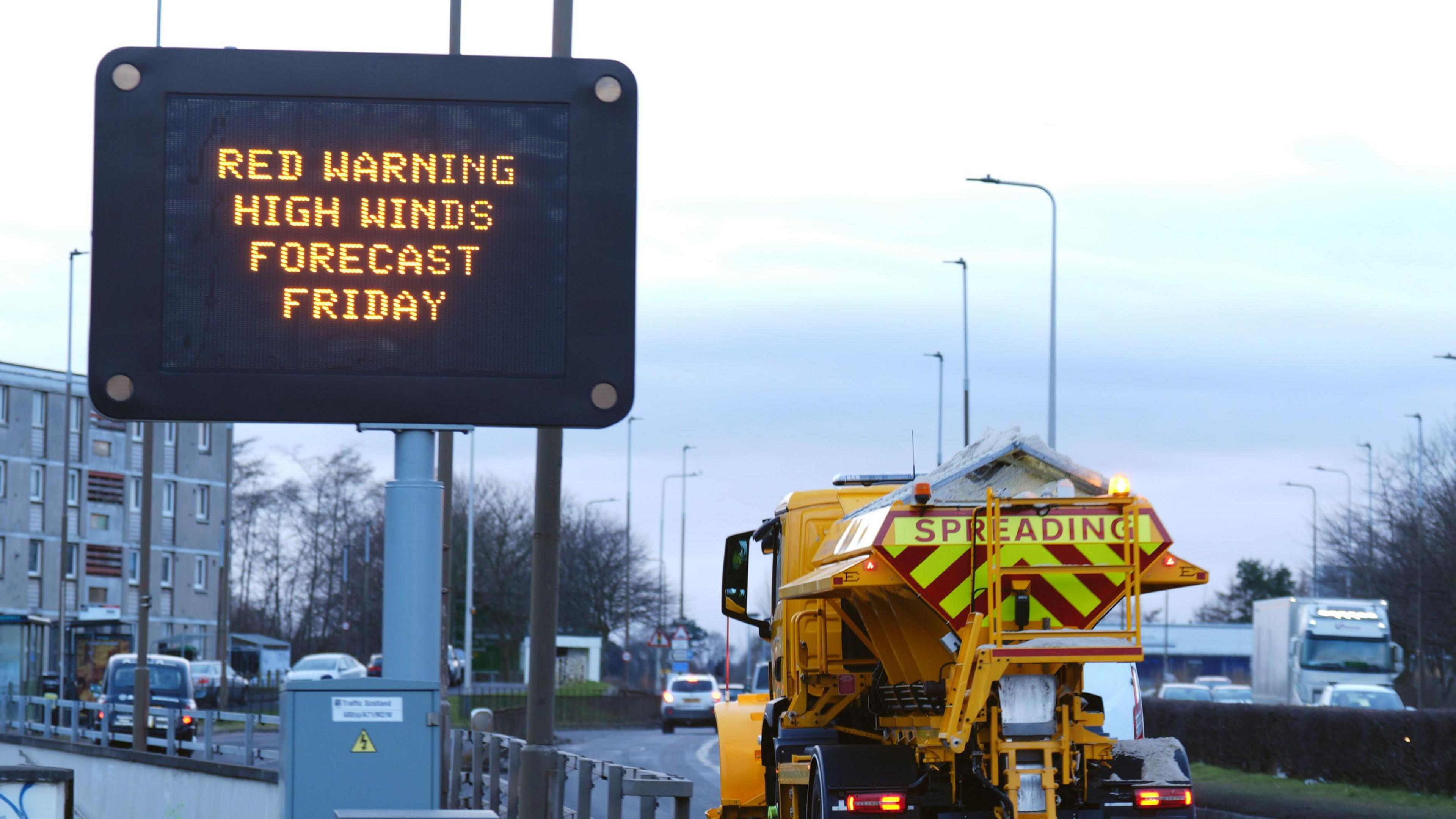 A road sign in Scotland warning of the red weather warning and high winds. 