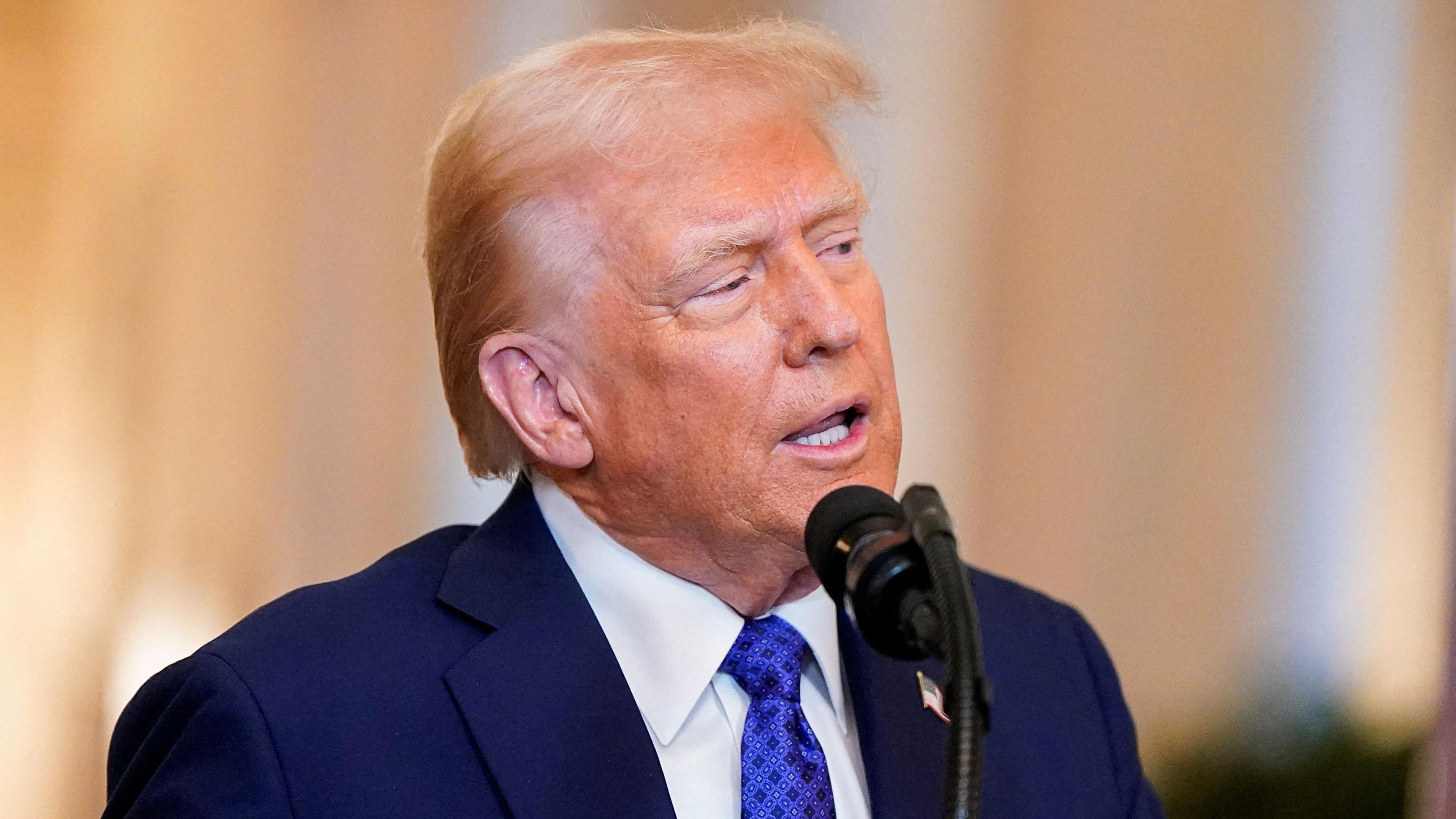 US President Donald Trump, wearing a blue suit and tie