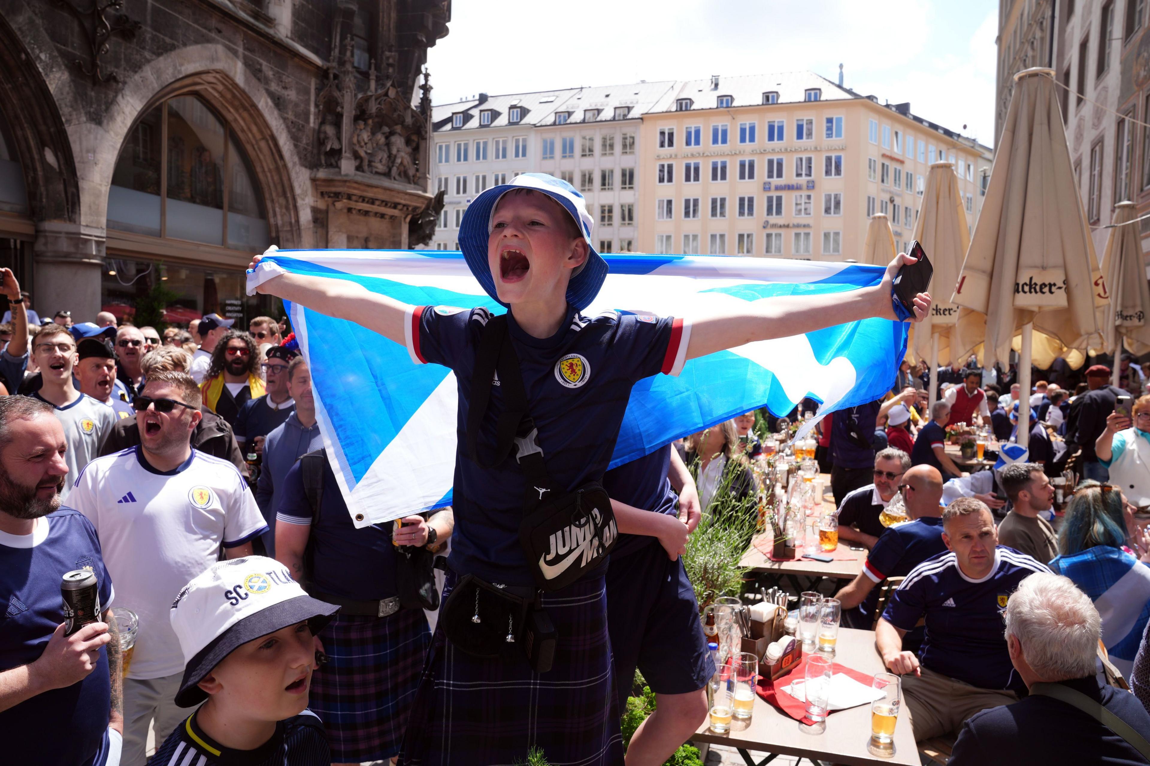 Young fan with a flag sings