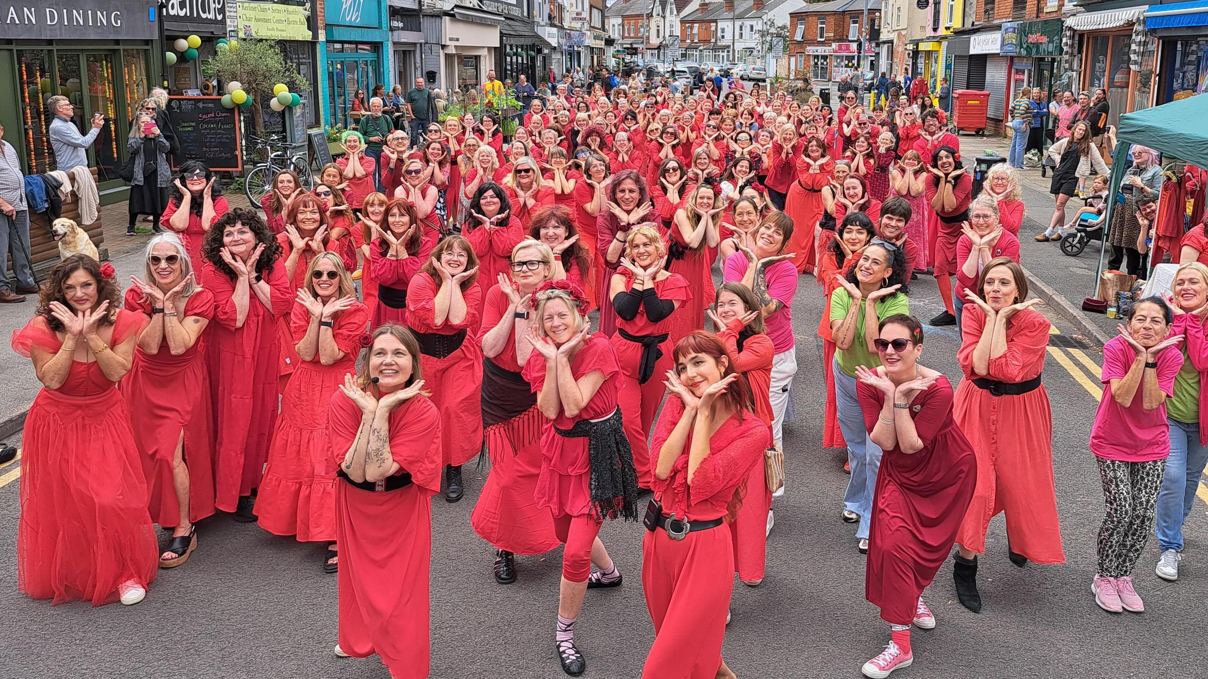 Dozens of women wearing red dance to Kate Bush's hit Wuthering Heights
