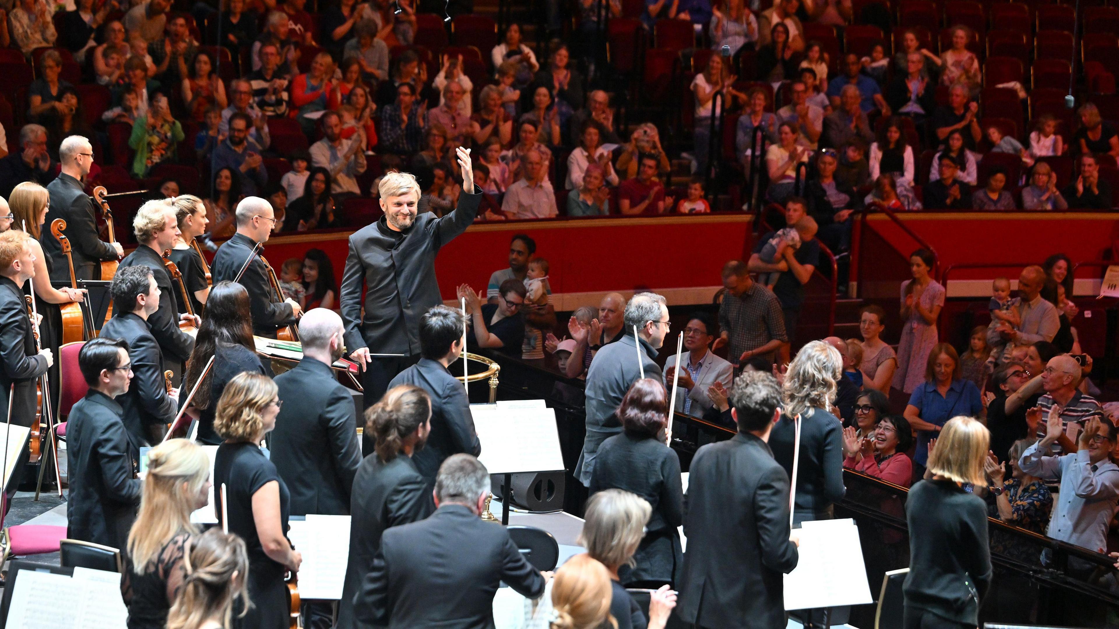 Bournemouth Symphony Orchestra and conductor Kirill Karabits standing on stage at the Royal Albert Hall