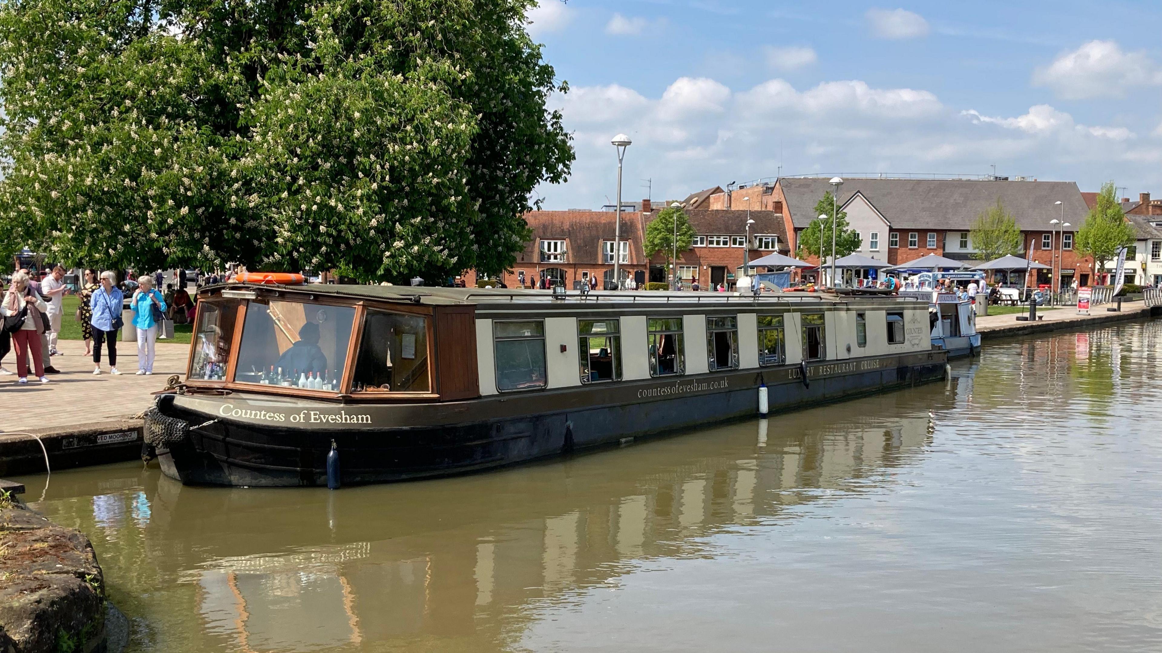 A canal boat restaurant named the Countess of Evesham, moored up on the canal next to a riverside walk