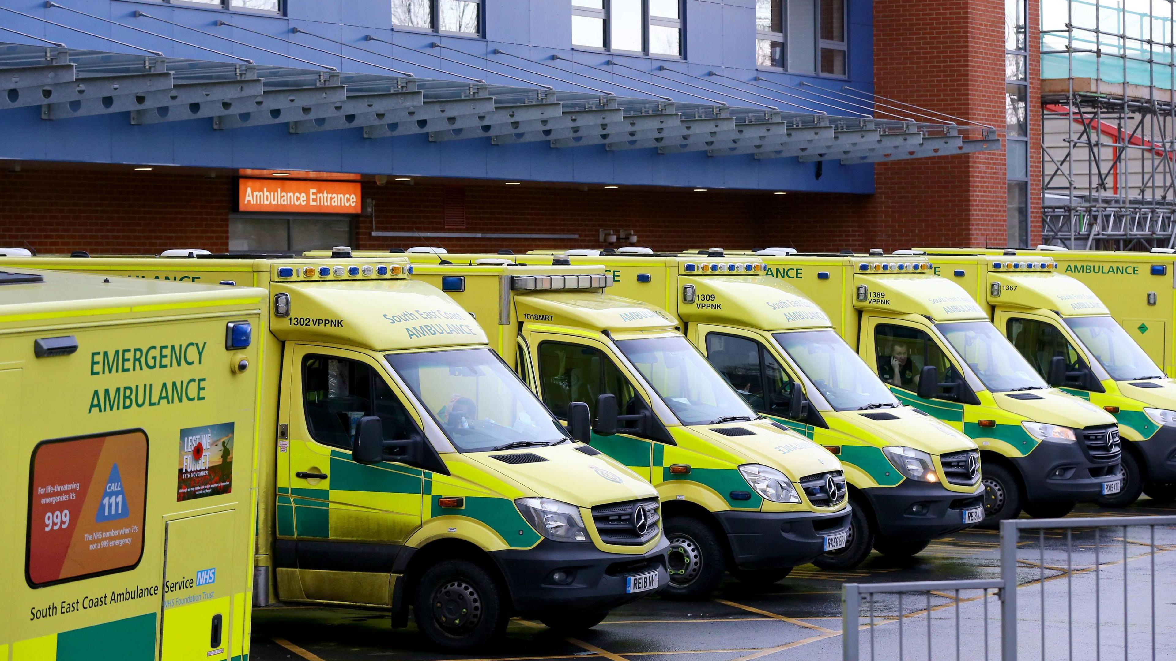 Half a dozen ambulances in fluorescent green and yellow livery, lined up outside Medway Maritime Hospital accident and emergency department