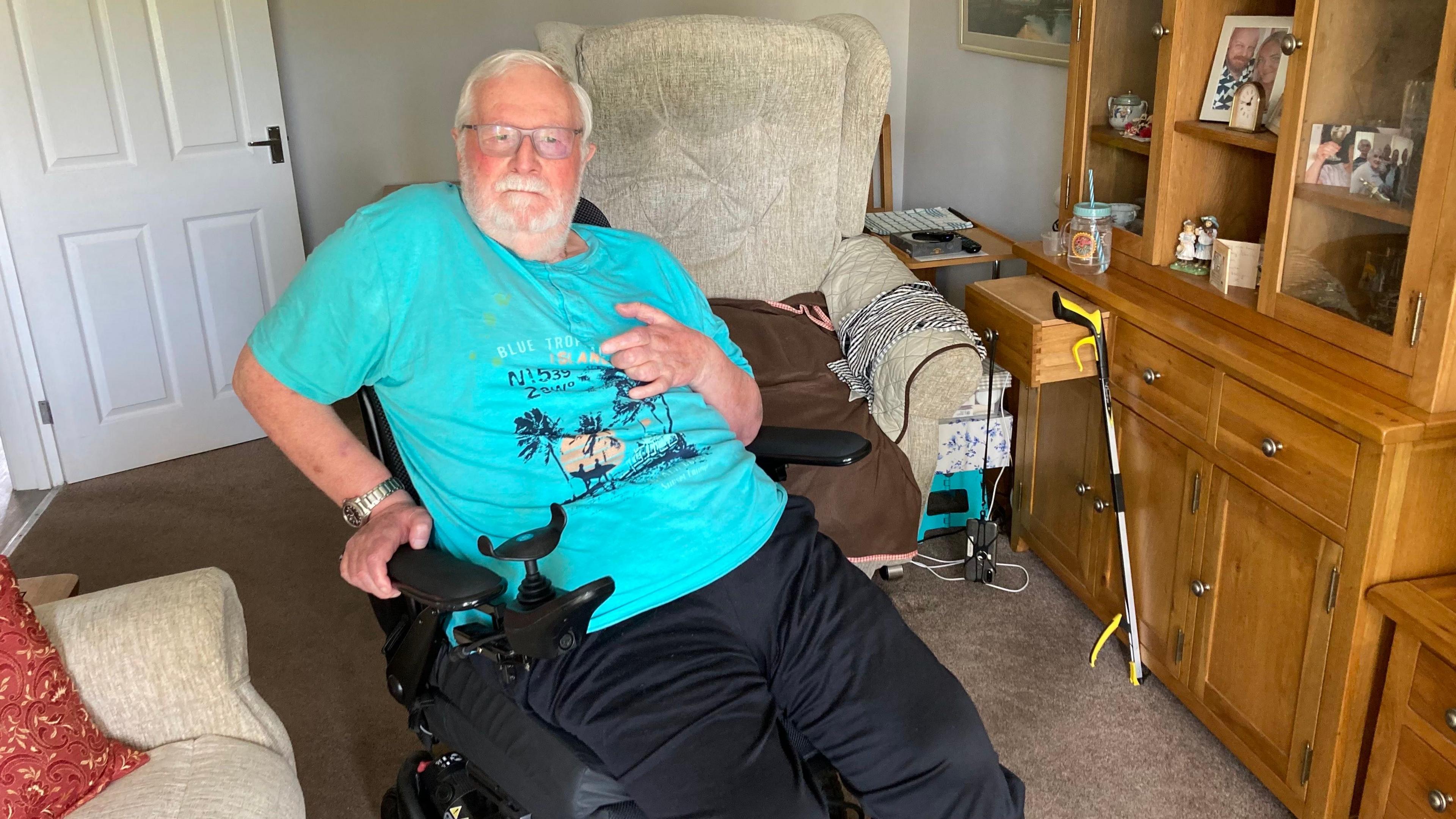 Roger Ellis is in a blue t-shirt sitting in a wheelchair