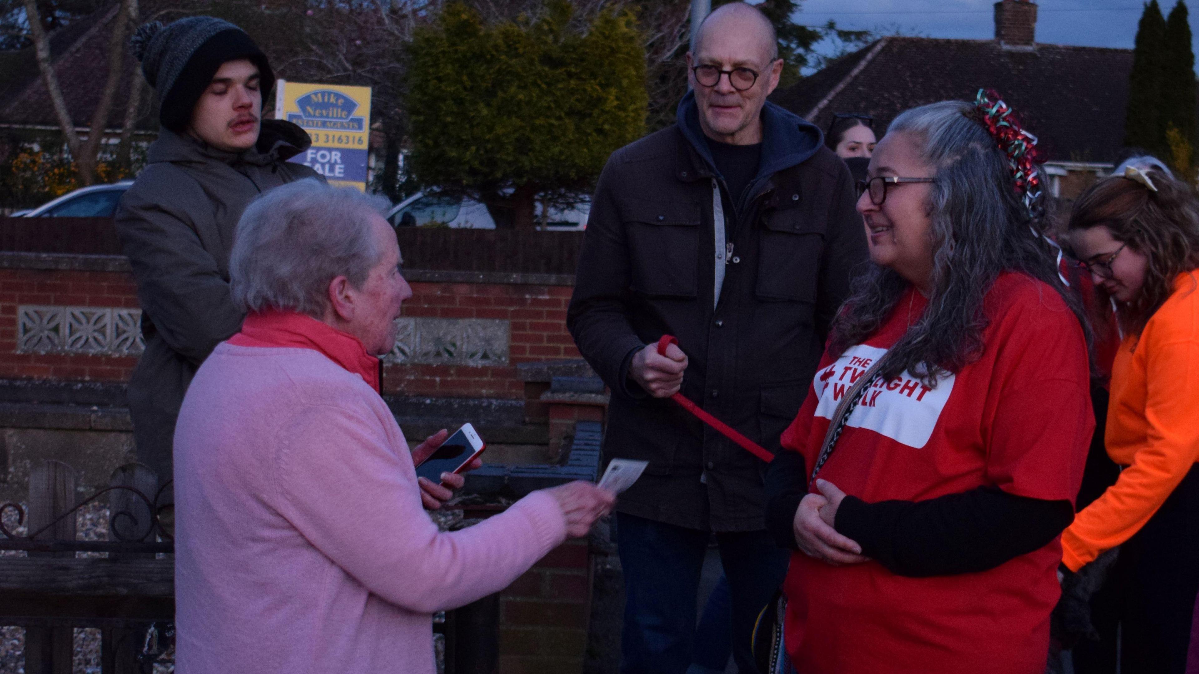 A woman donating money to a group of people in Rushden