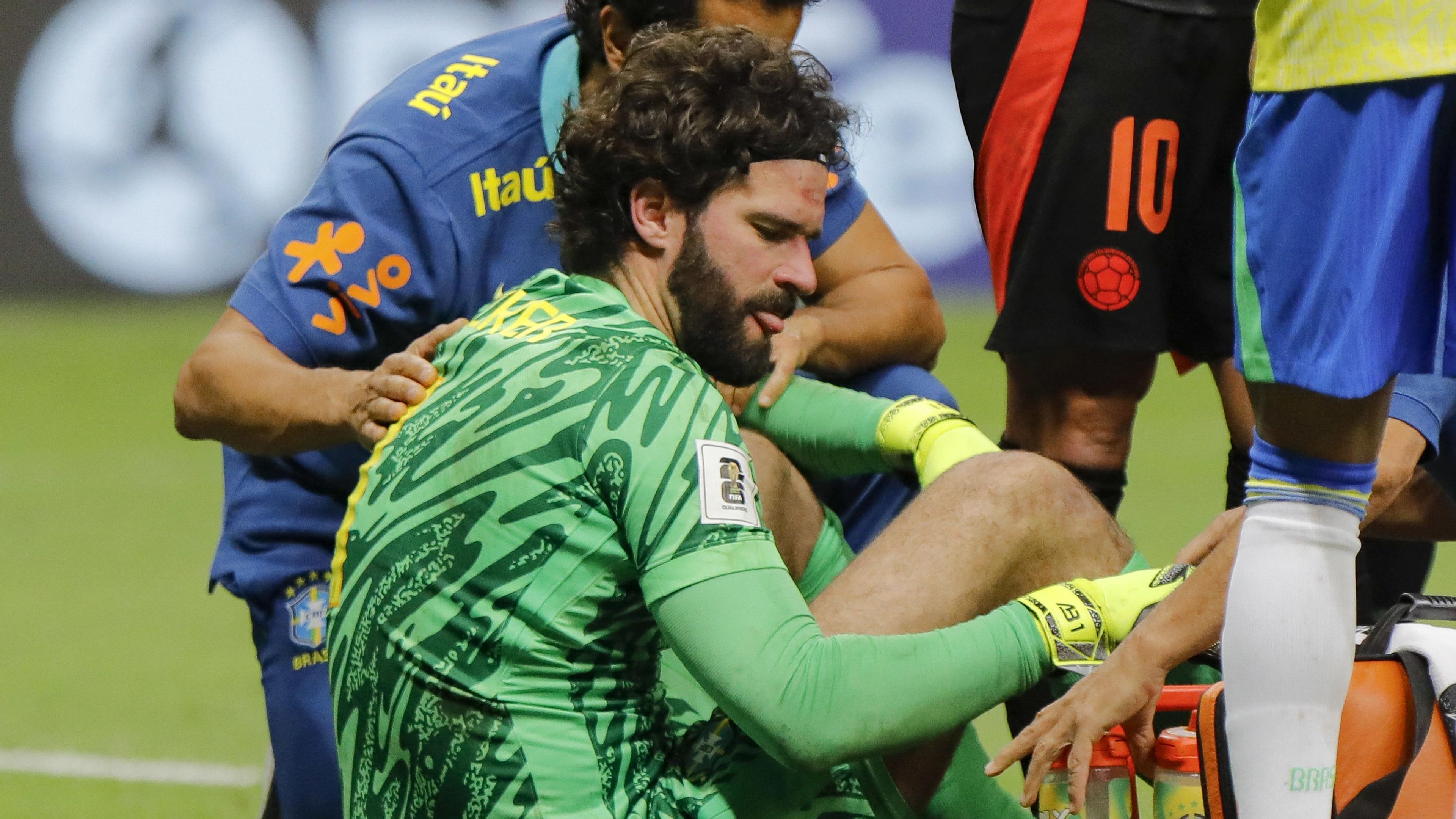 Brazil goalkeeper Alisson Becker receives treatment after a clash of heads in World Cup qualifier against Colombia