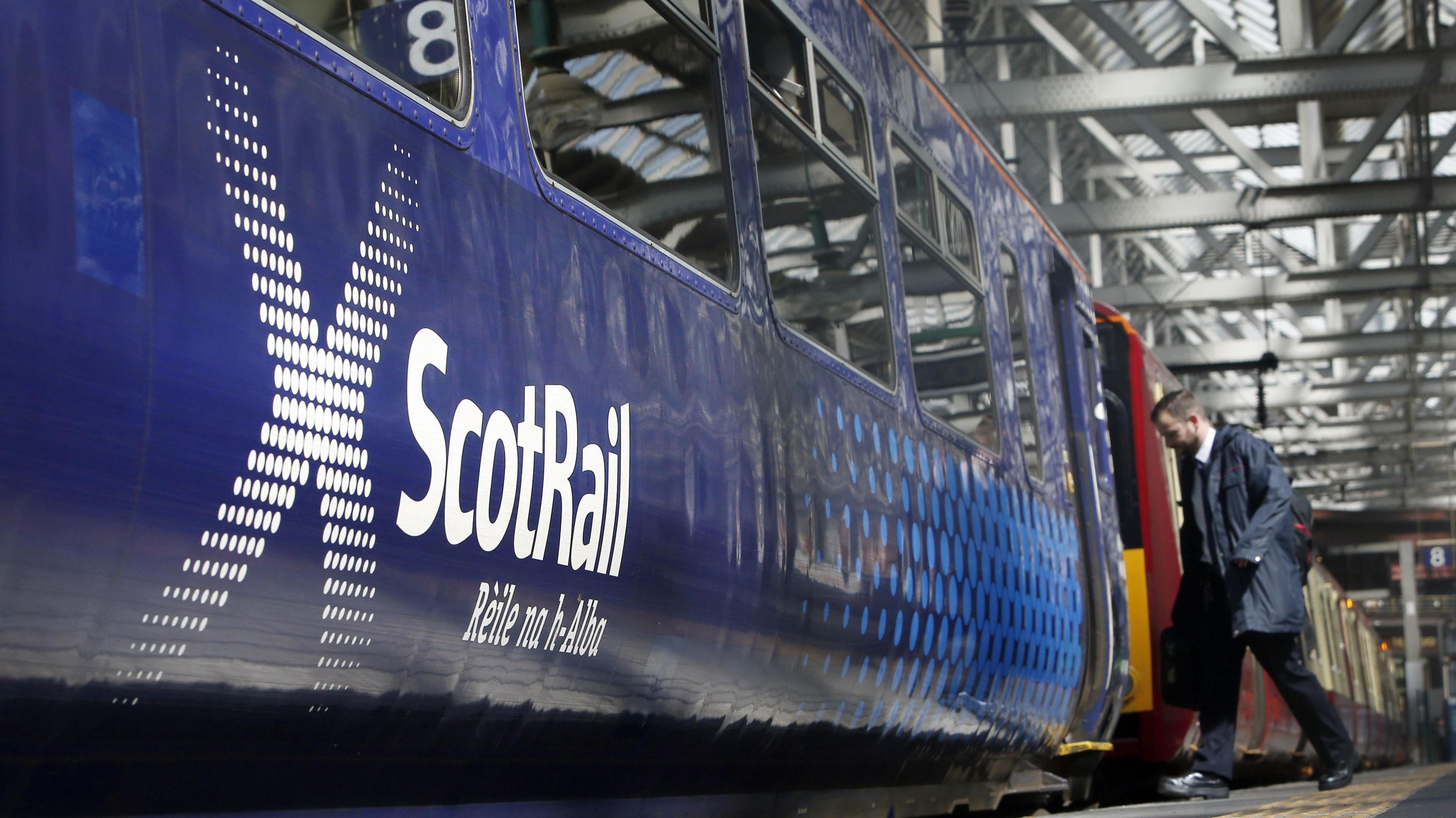 A passenger boarding a ScotRail train