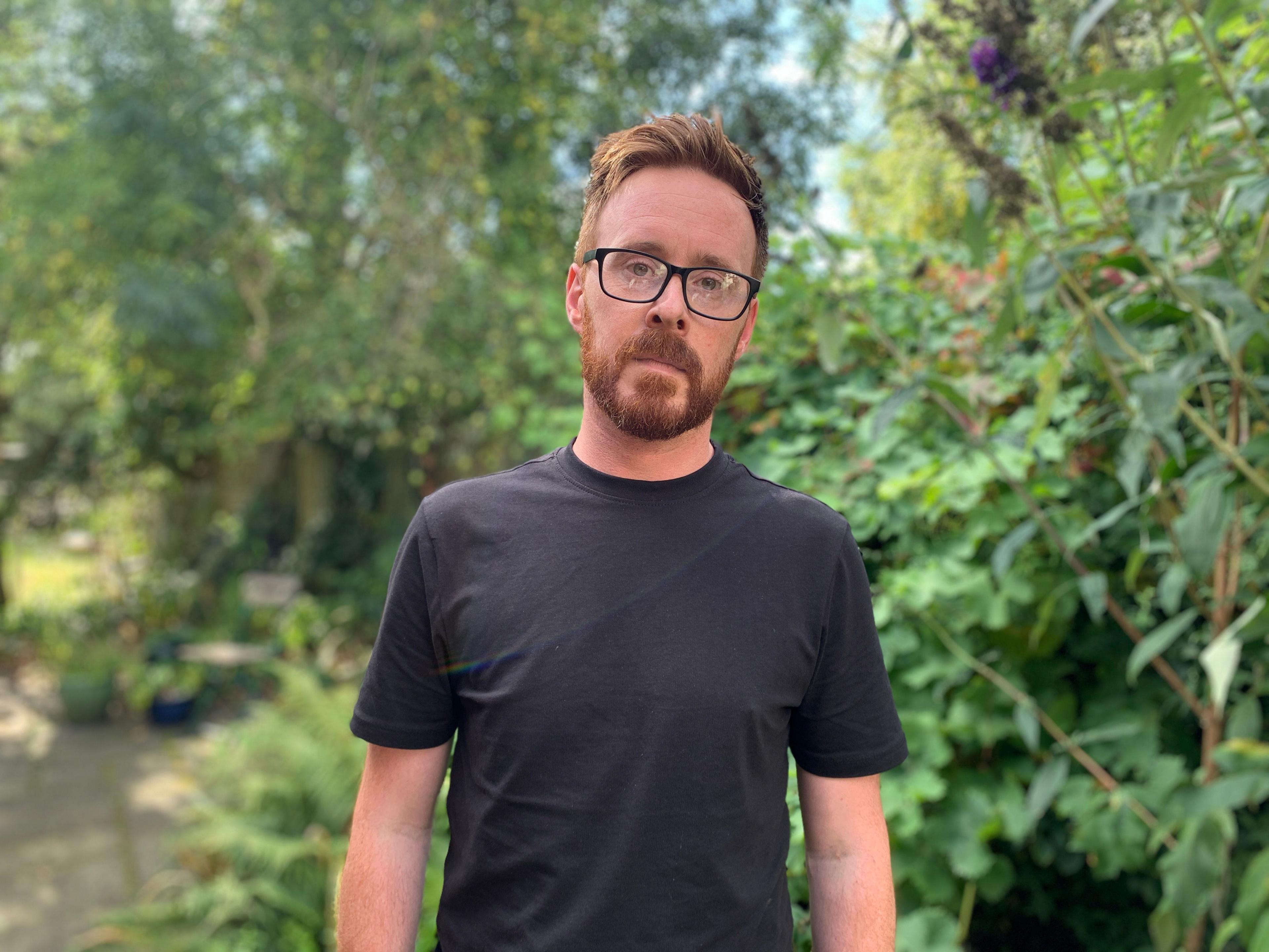 Stephen Webb in front of a backdrop of greenery