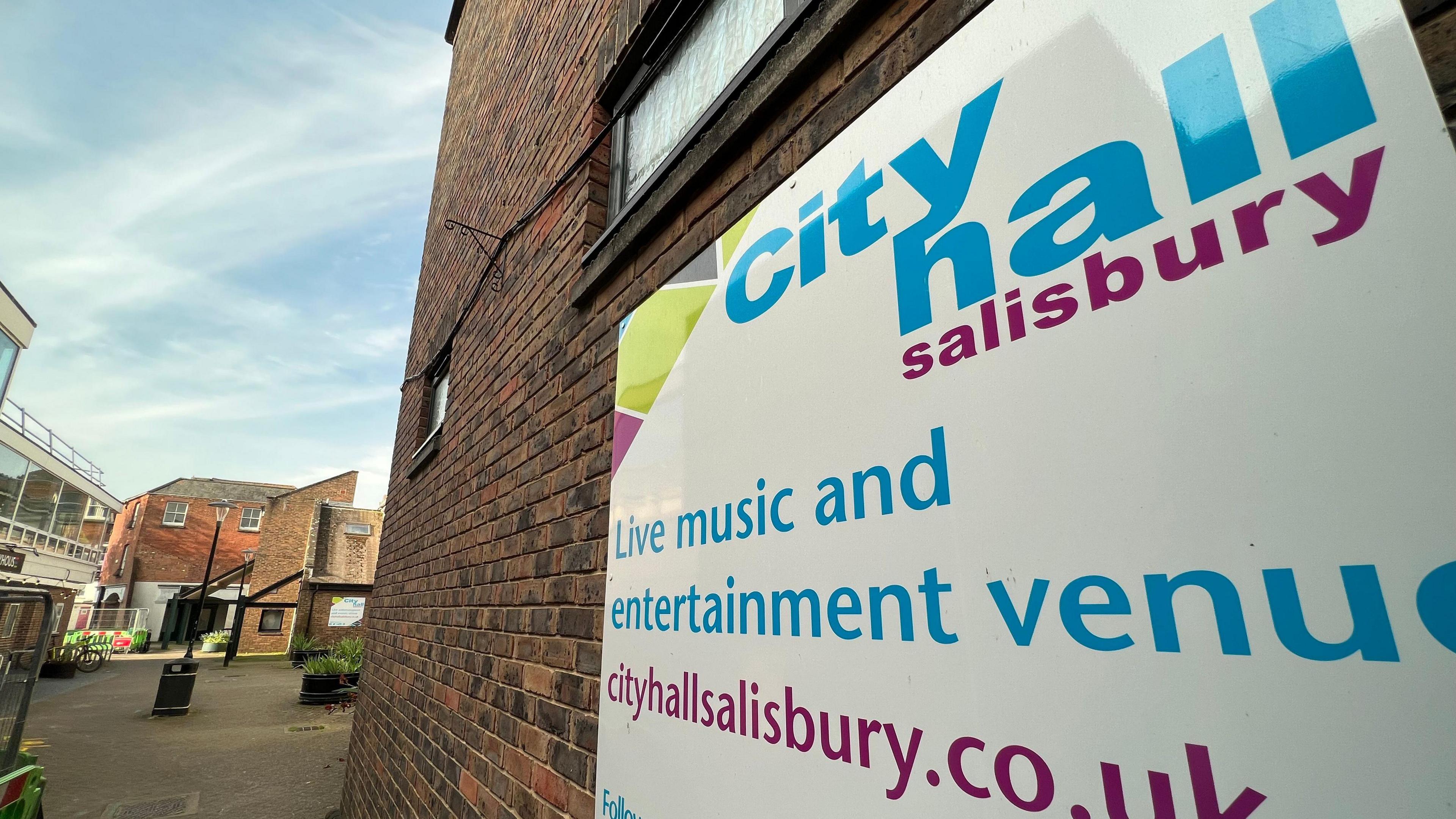 A close-up of one of the city hall Salisbury signs on the side of the red-brick building.