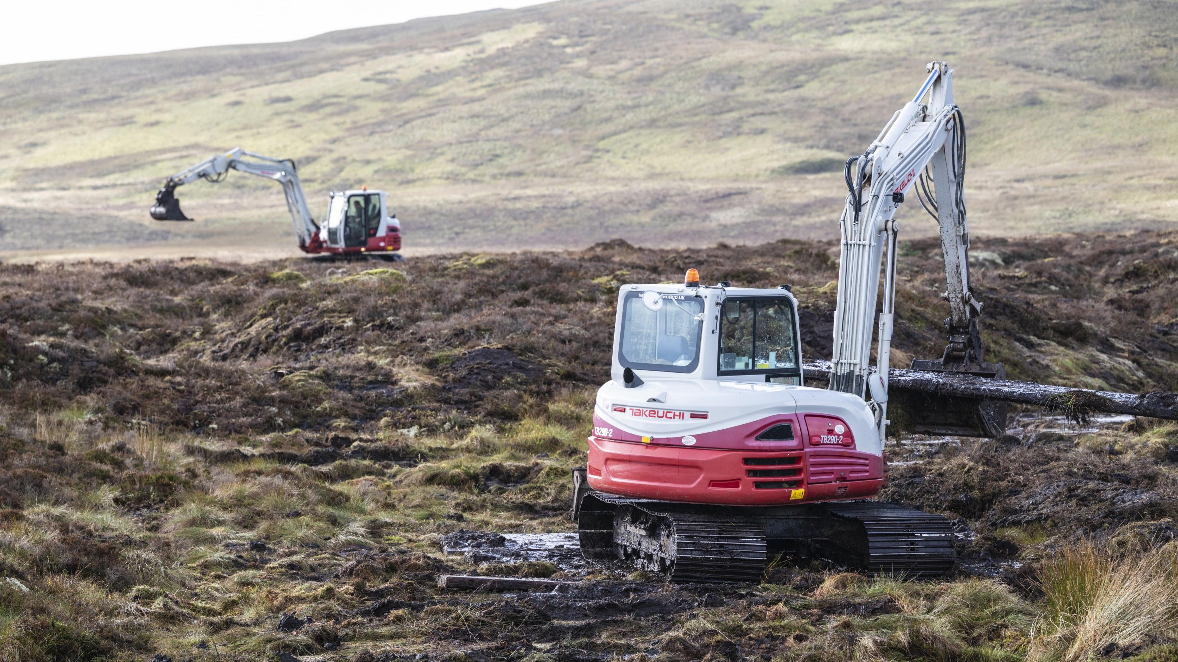 Cloddwyr coch a gwyn yn casglu mat cors oddi ar dir y Migneint