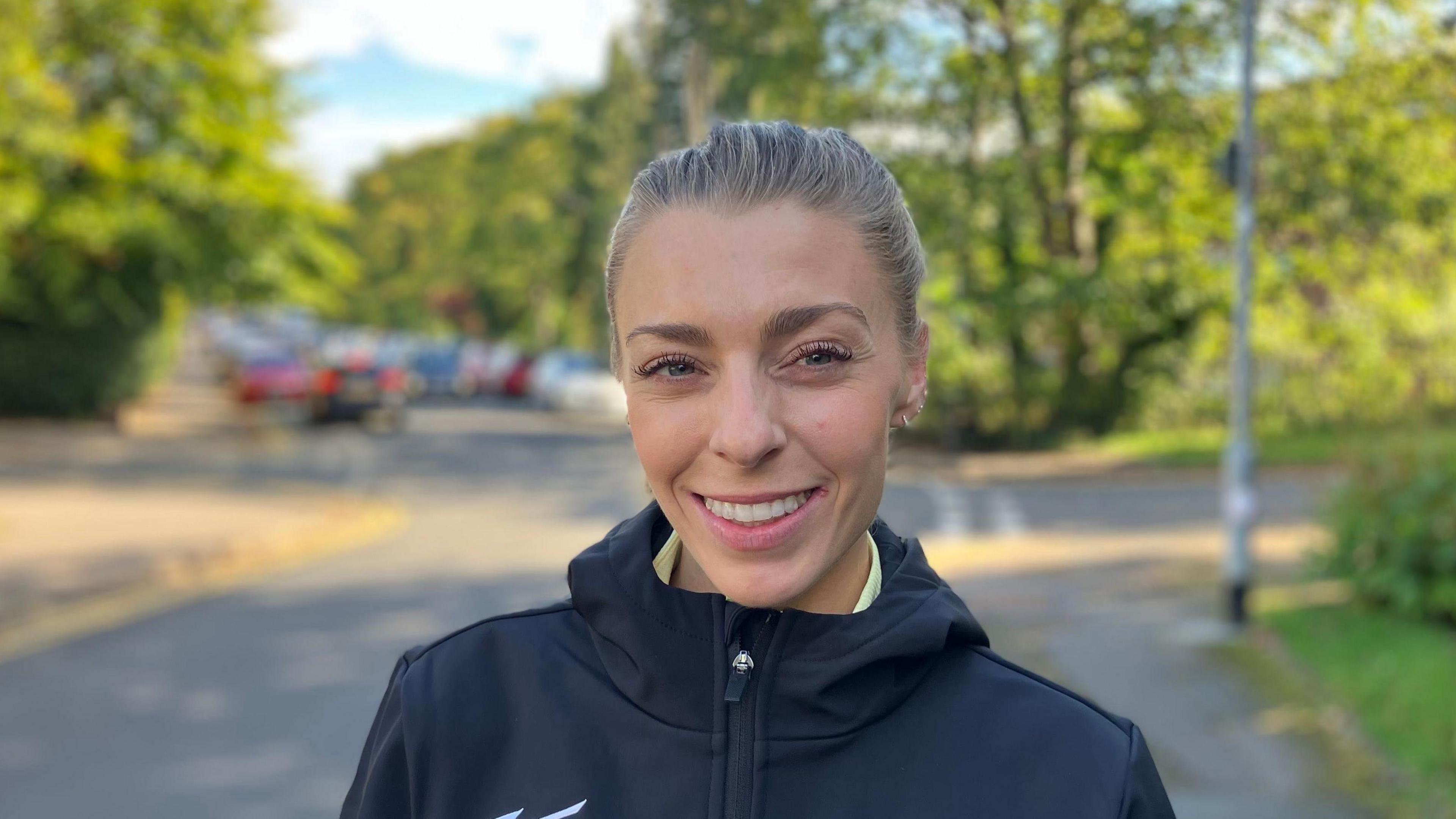 Alex Bell, who has blonde hair. She is smiling in the photo.