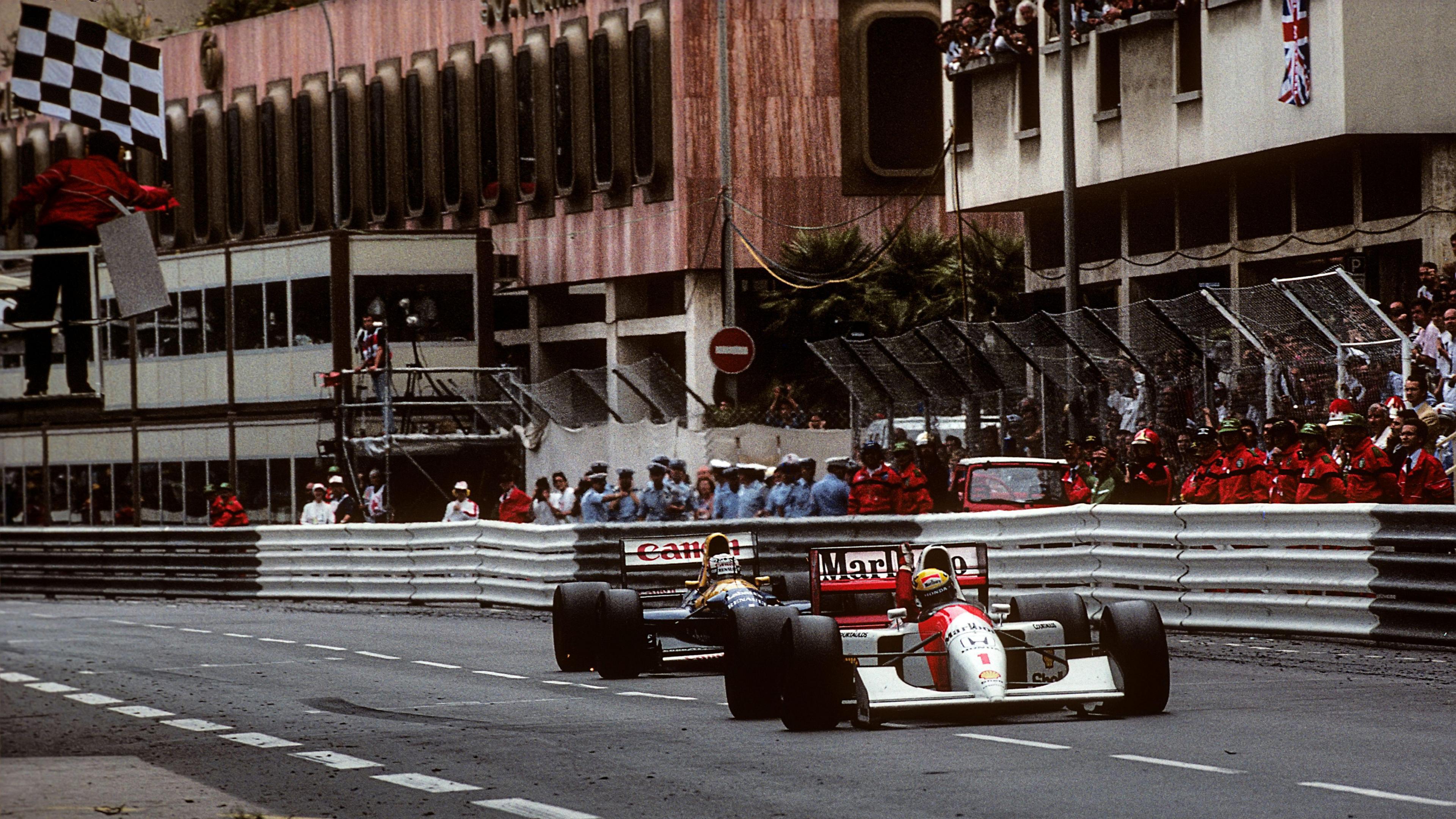 McLaren's Ayrton Senna raises his arm aloft in triumph as he crosses the line to win in 1992 with Williams' Nigel Mansell right behind him