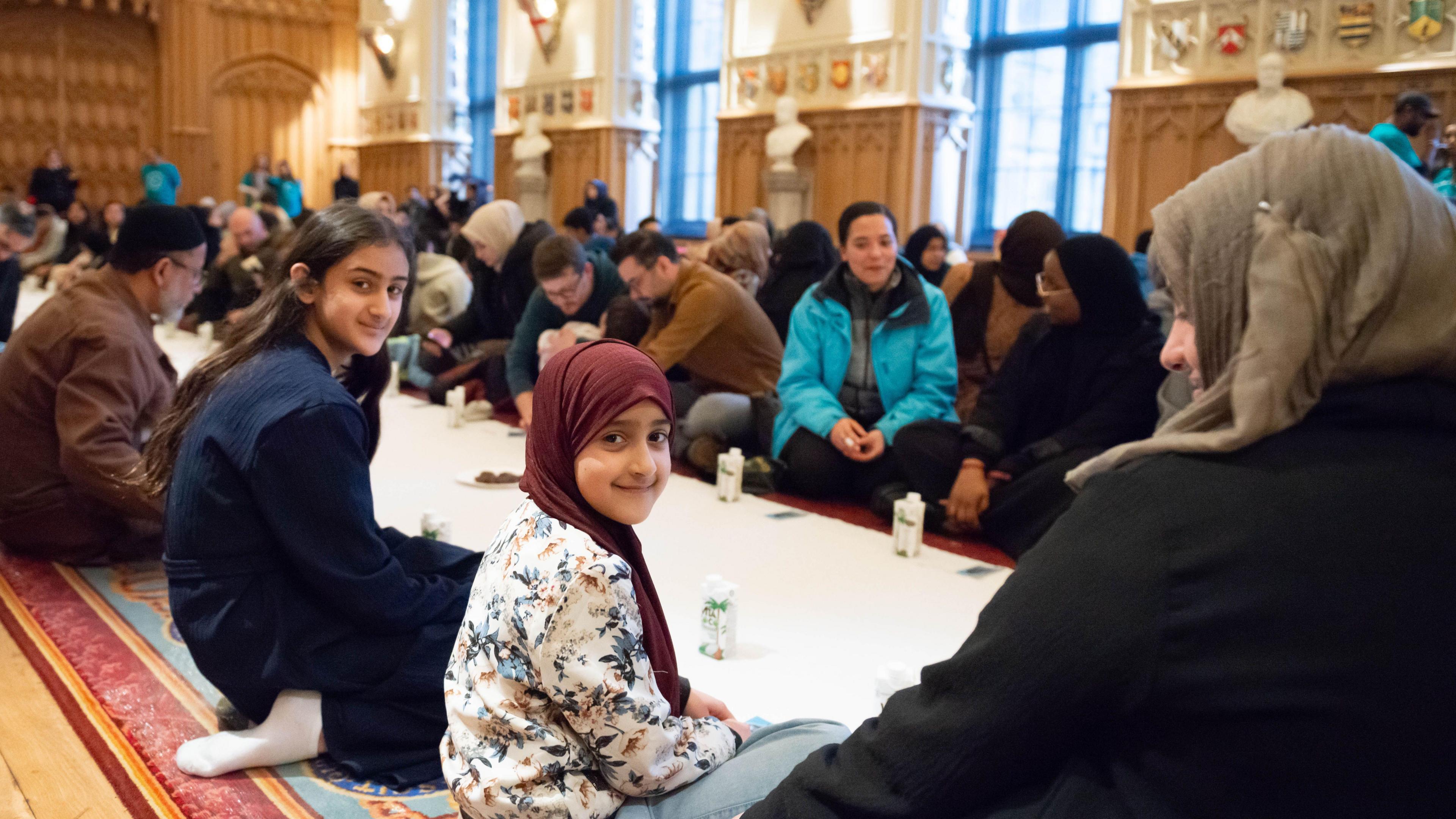 Guests breaking their fast with dates and water, and sharing a meal in St George’s Hall.