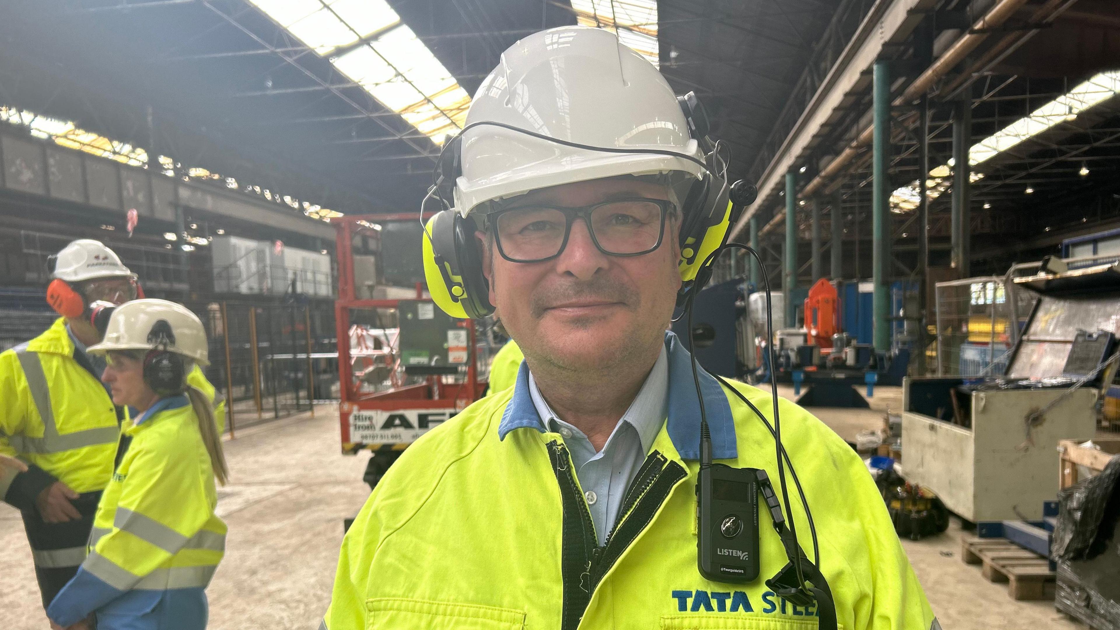 Lee Barron MP, who is wearing a high-vis jacket, a safety hat and ear defenders, at the Tata Steel factory in Corby