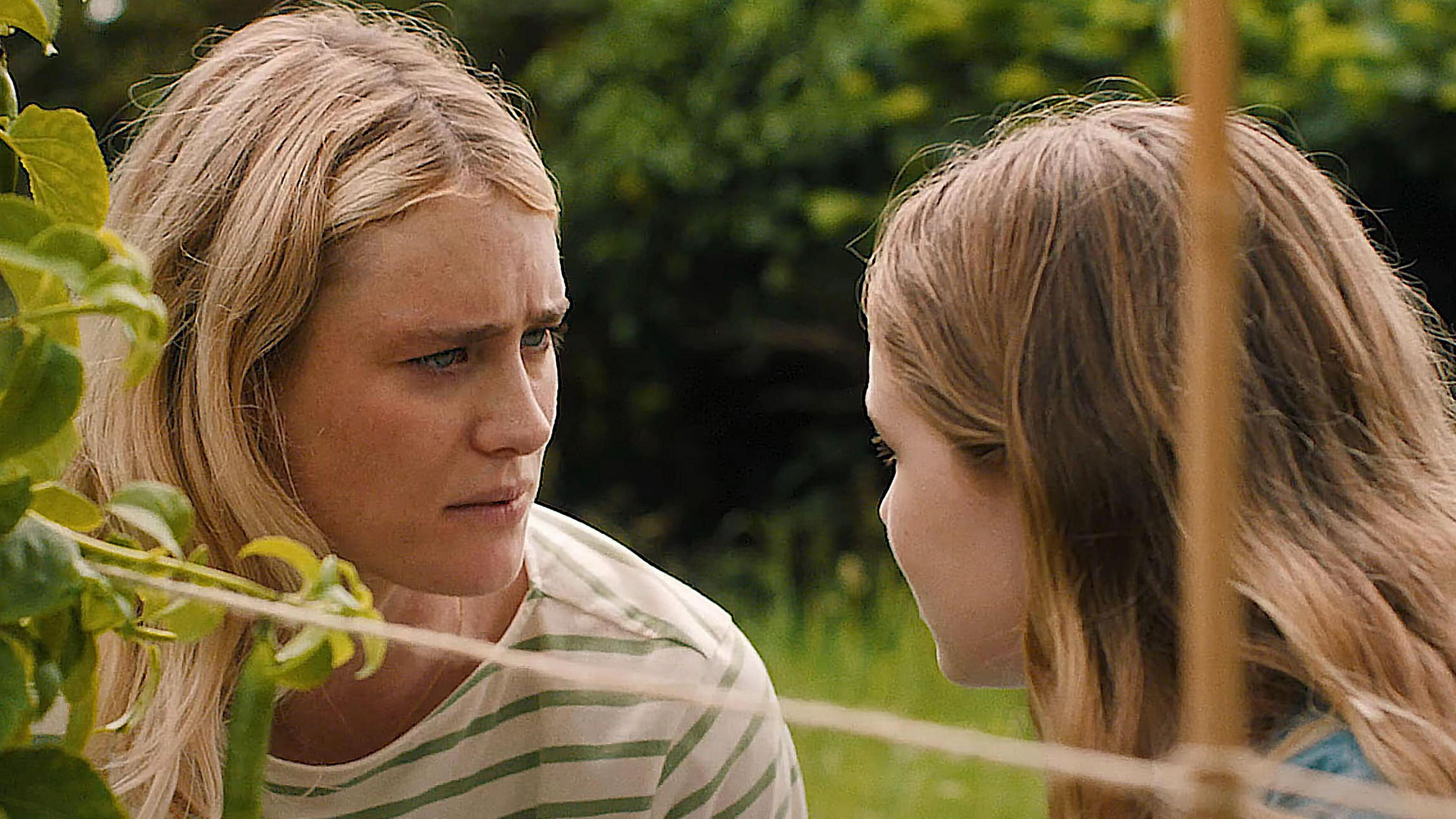 Mackenzie Davis as Louise, listening to her character's daughter Agnes, played by Alix West Lefler