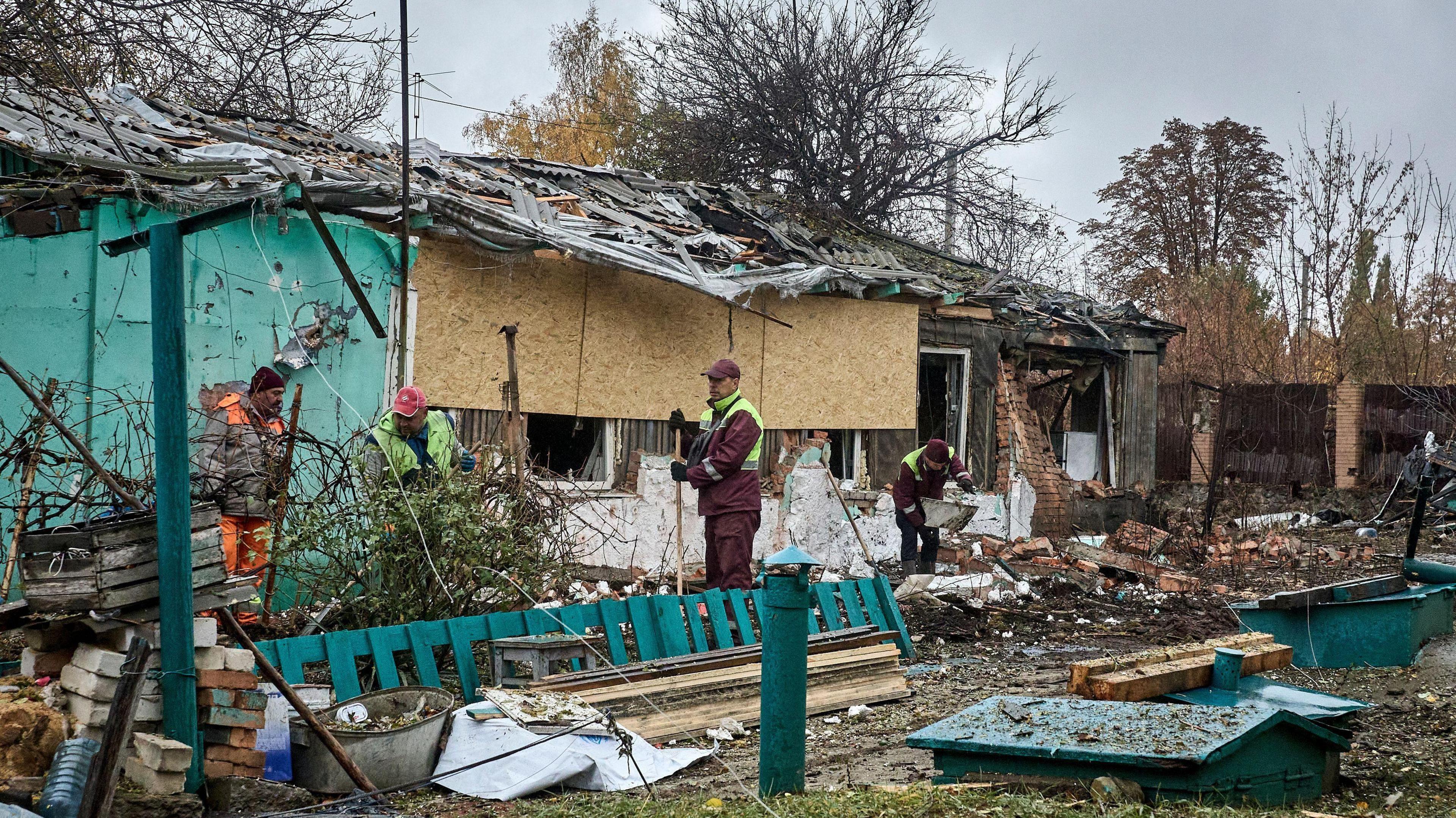Ukrainian workers work at the site of an airstrike on a private building in Kharkiv, northeastern Ukraine, 21 October.