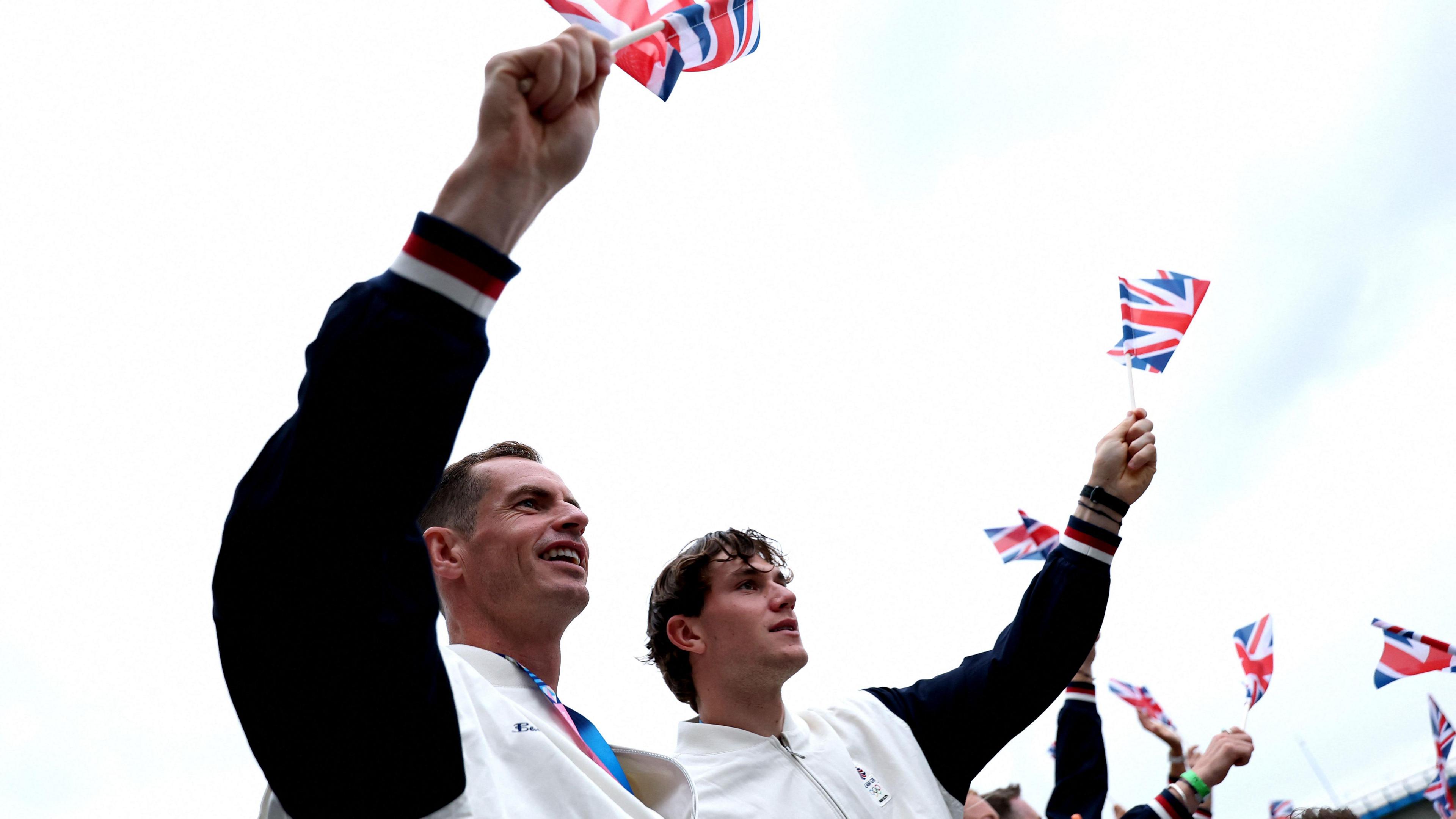 Andy Murray and Jack Draper waves British flags at the 2024 Olympic Games opening ceremony in Paris