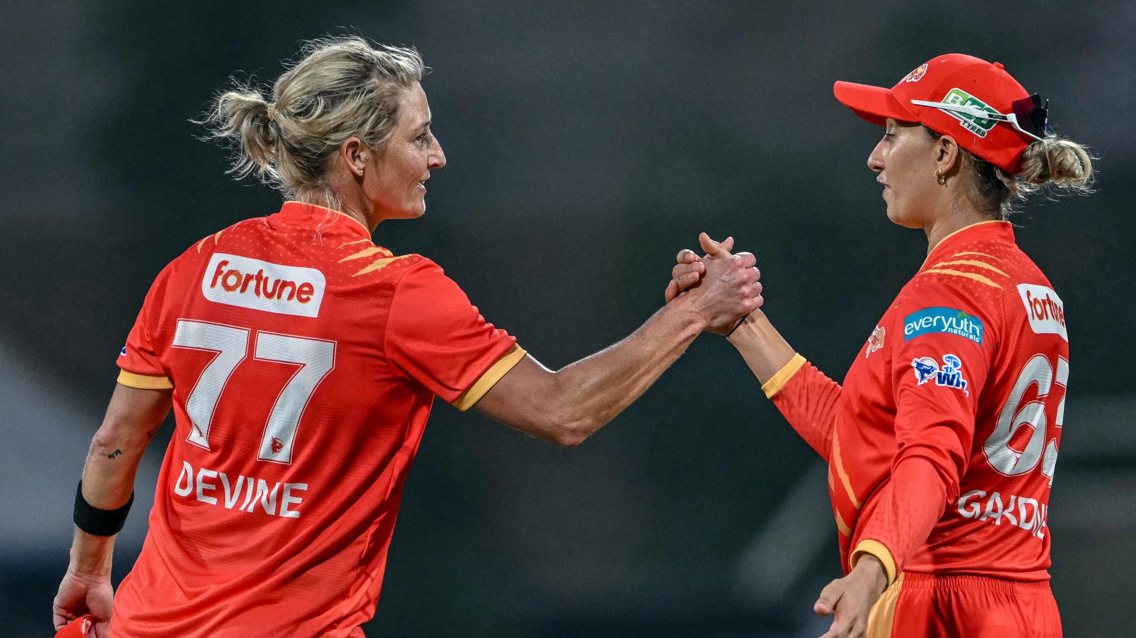 Sophie Devine shales hands with Ash Gardner