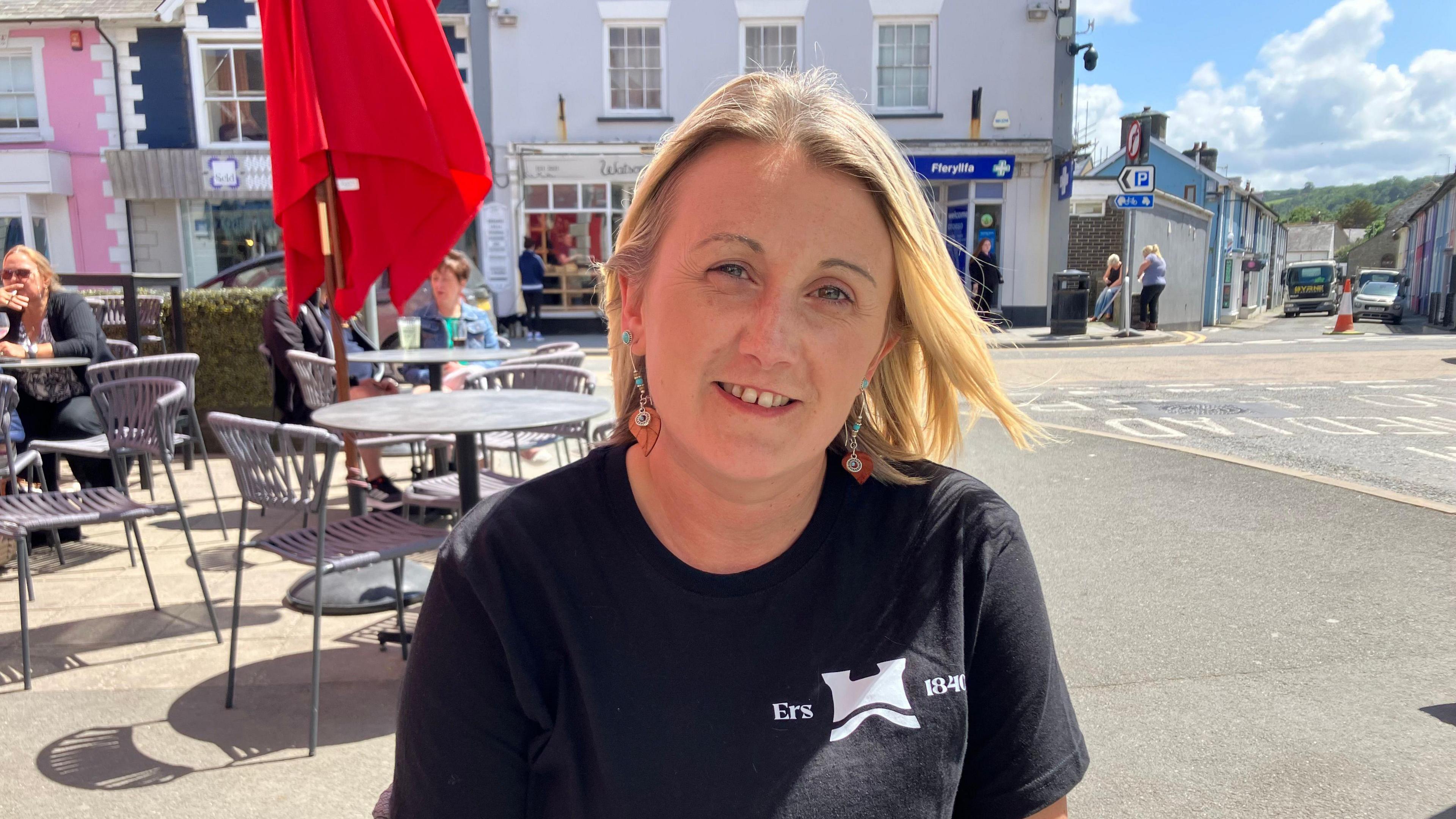 Donna Regan, Manager of the Castle Hotel sitting outside the hotel in Aberaeron.
