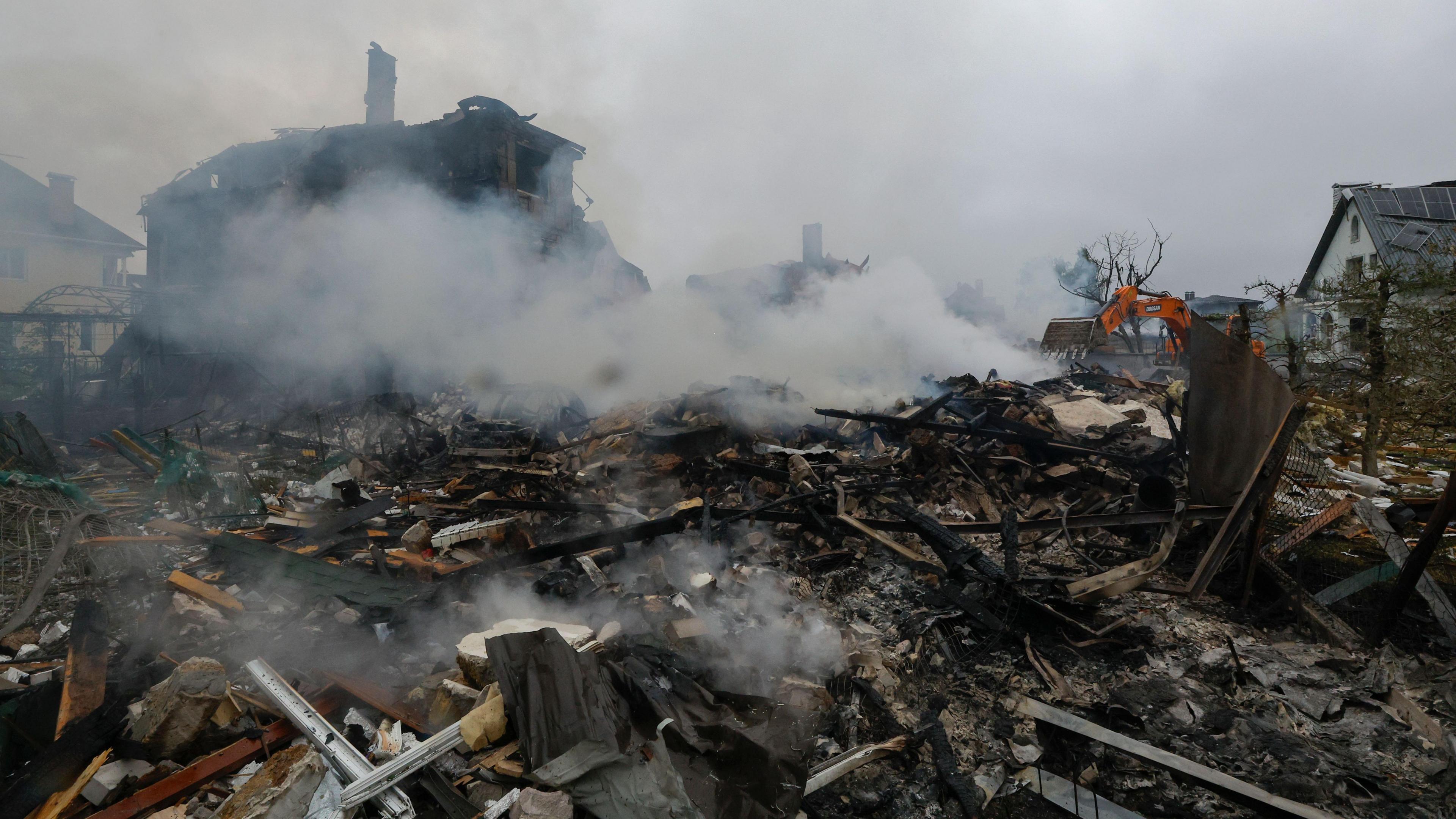 Ukrainian rescuers work at the site of a residential area struck by a rocket as a result of an overnight strike in a village near Kyiv, Ukraine.