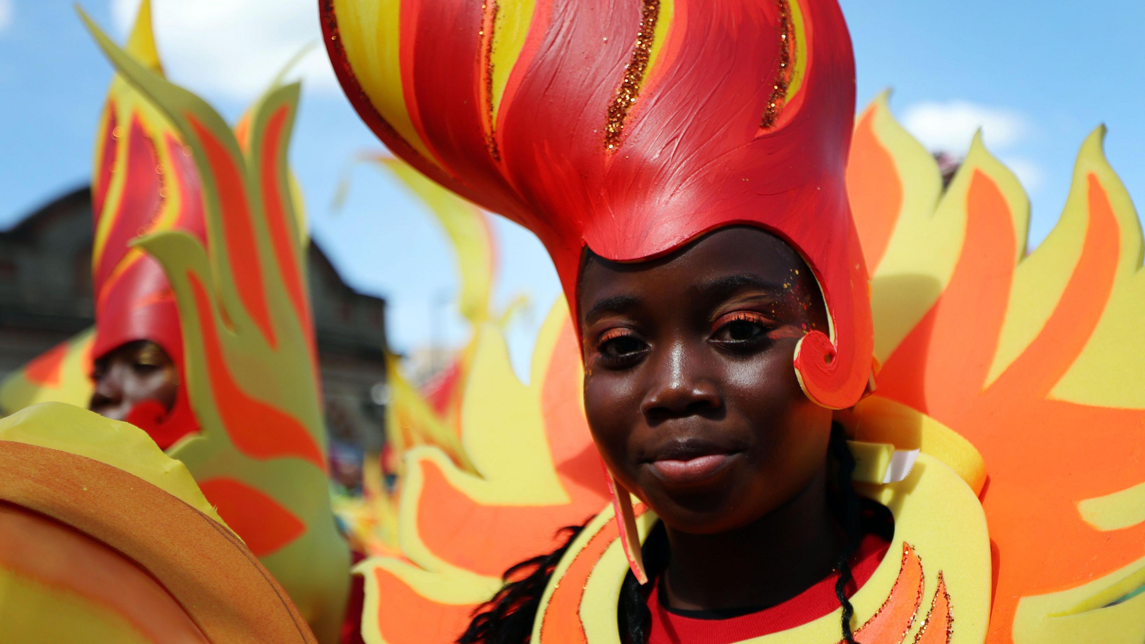 A girl wears a red and orange costume that appears to look like flames.