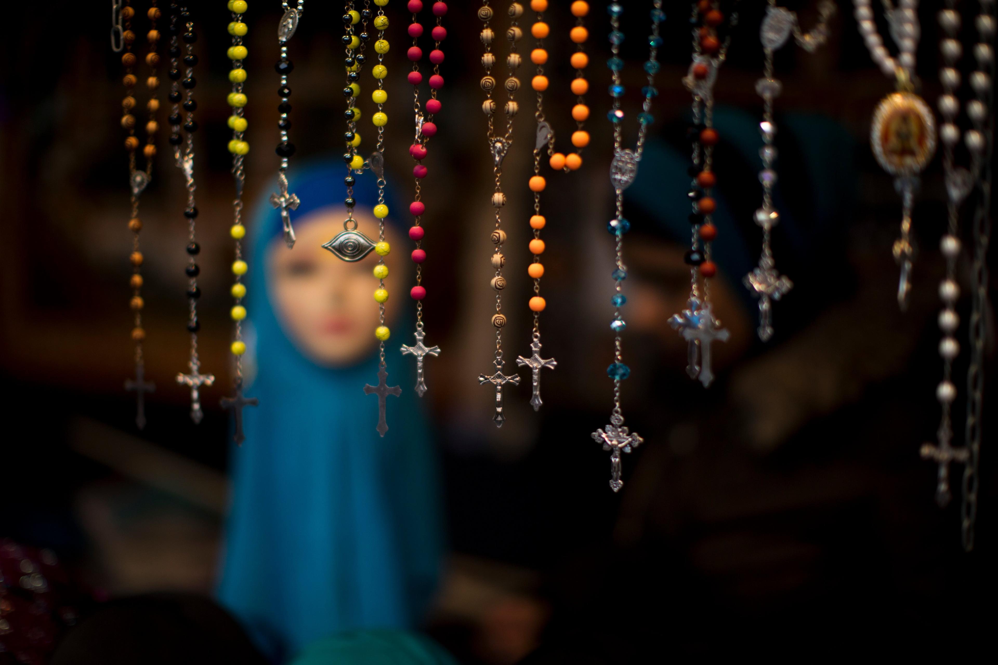 Rosary beads are displayed for selling next to a mannequin wearing a headscarf in a market stall at The Hague, The Netherlands.