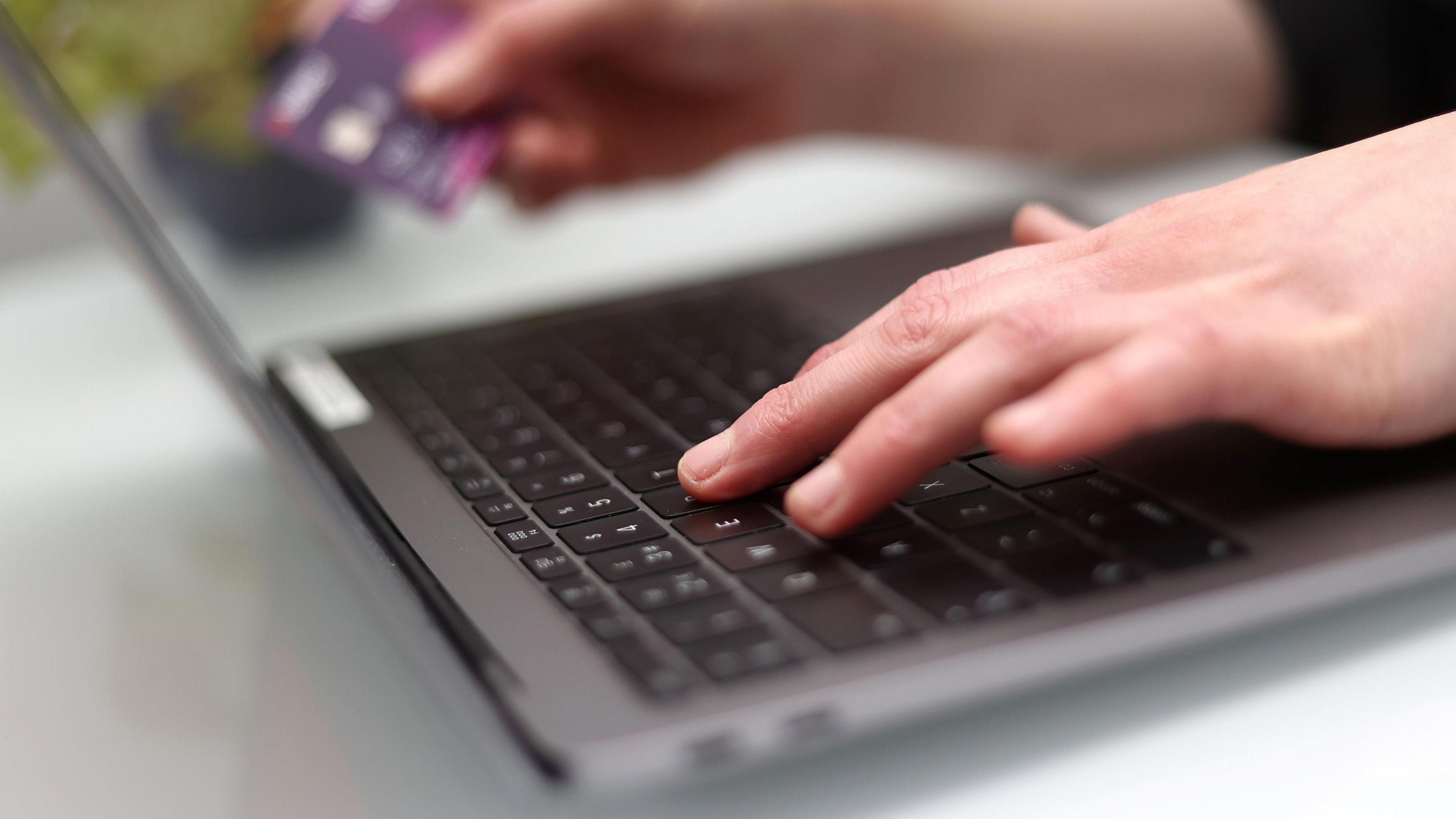 Someone's hands typing on a laptop keyboard 