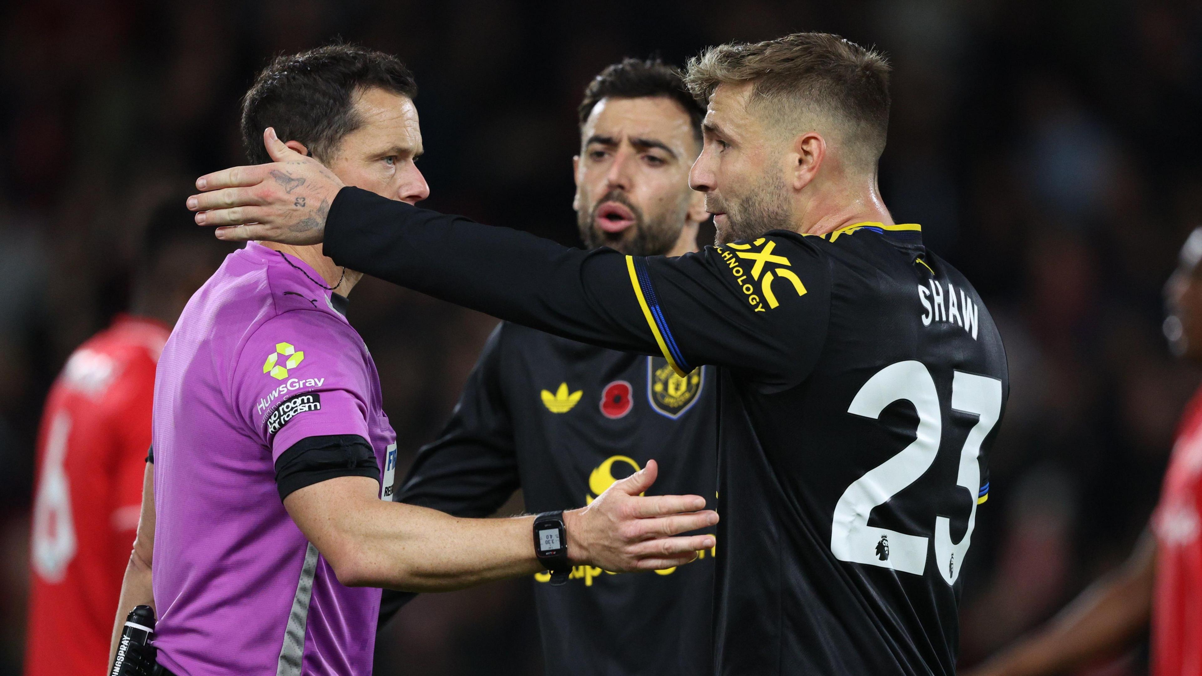 Luke Shaw and Bruno Fernandes with the referee