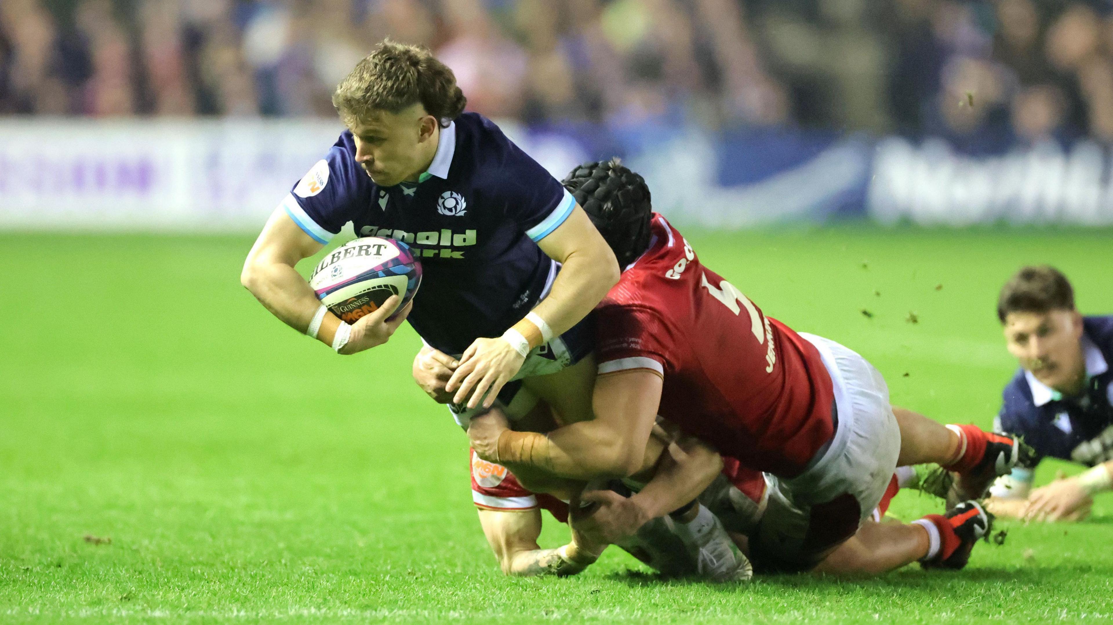 Scotland's Kyle Rowe being tackled by Wales' Dafydd Jenkins.