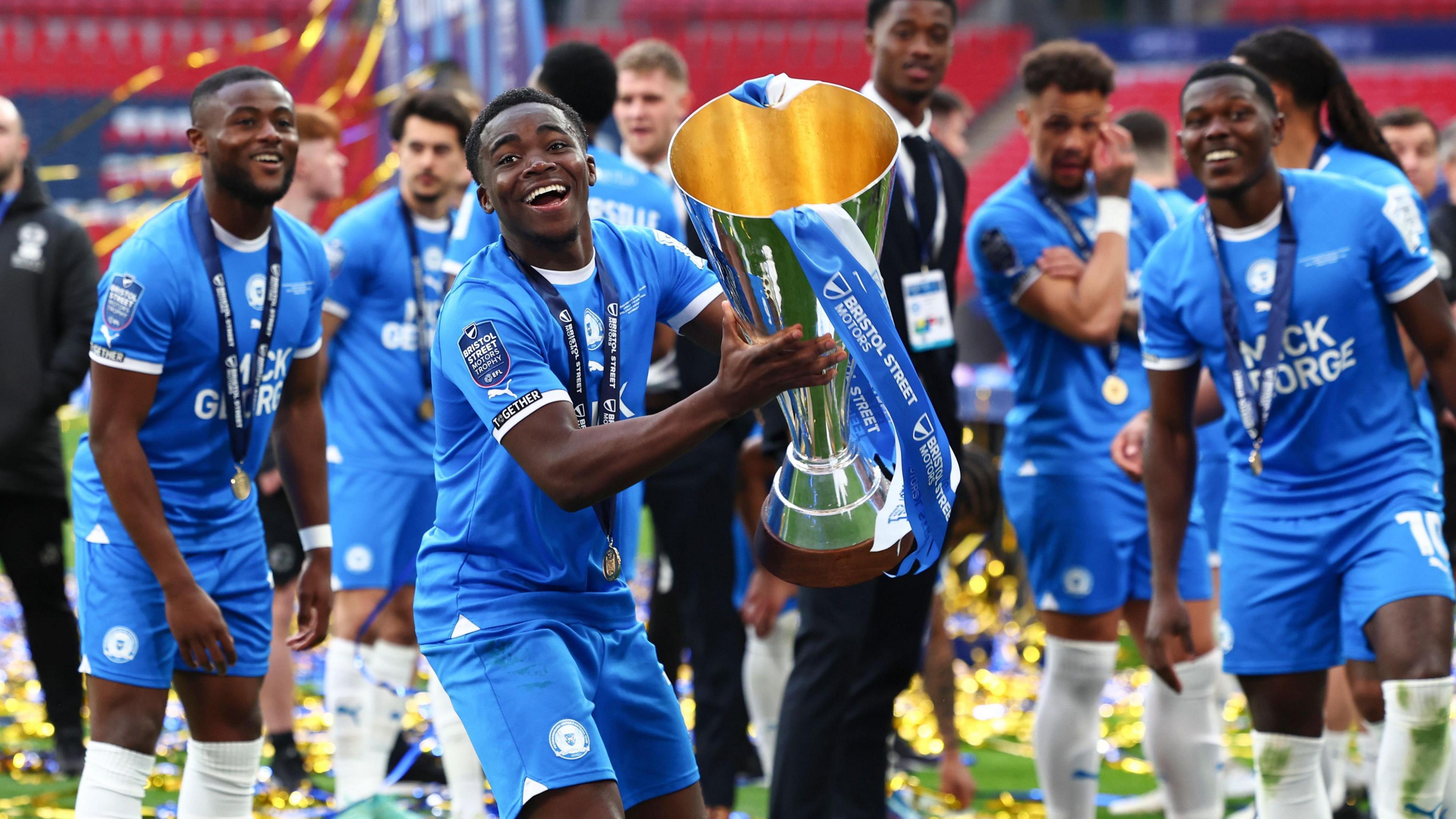 Kwame Poku celebrates with the Bristol Street Motors trophy at Wembley