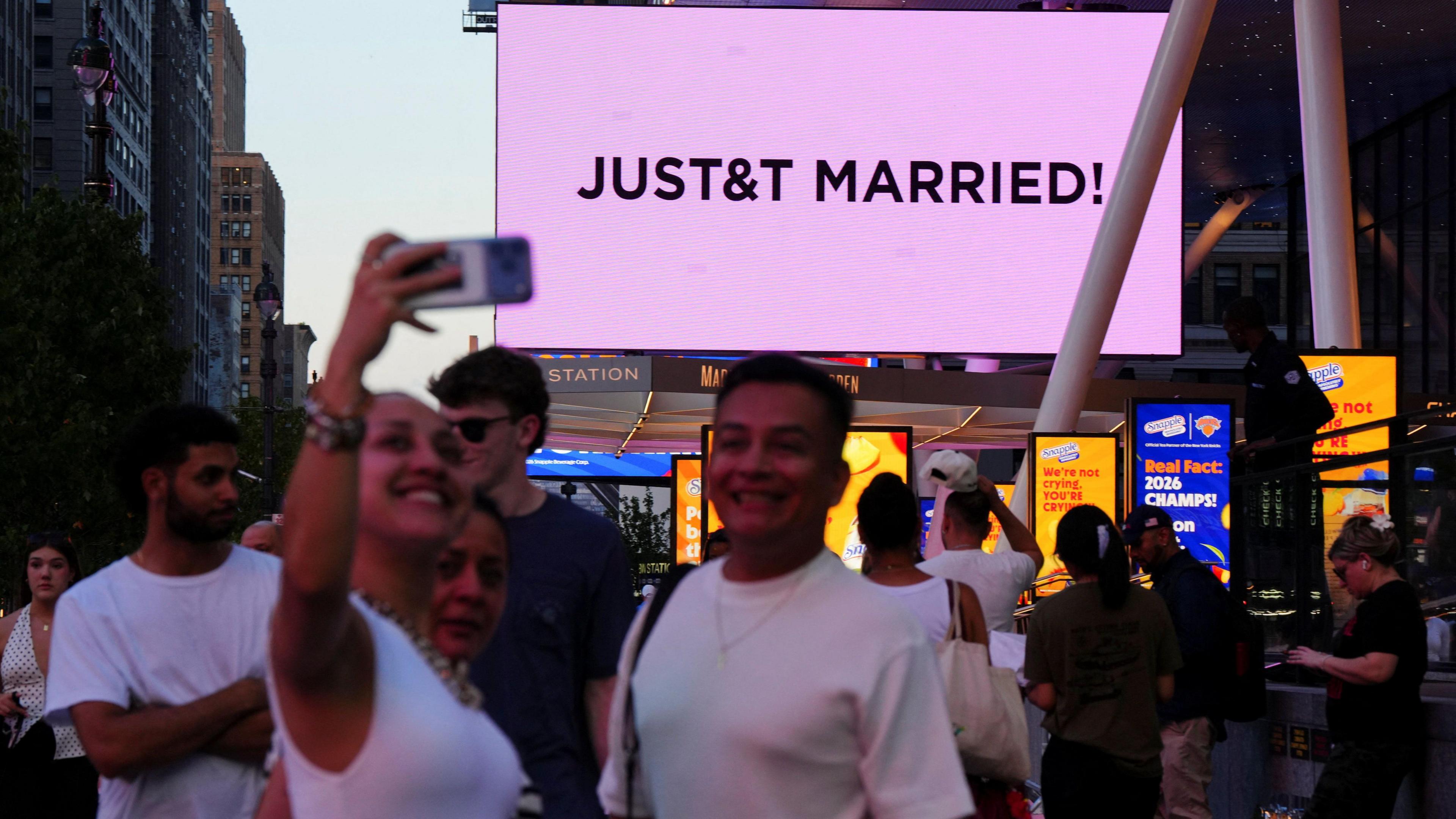 A woman pictured taking a selfie with the "JUST&T MARRIED" announcement