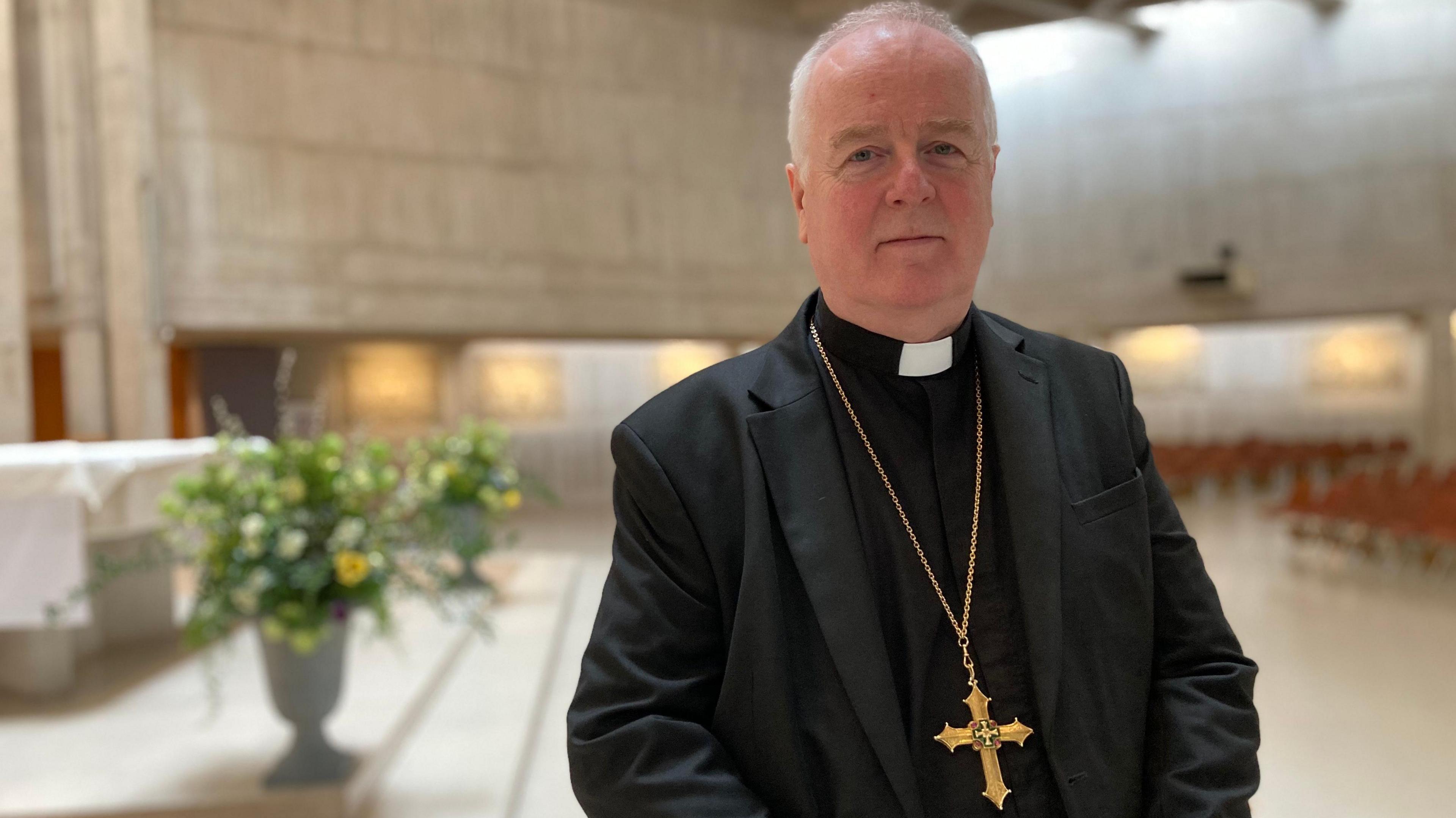 Bishop of Clifton Bosco MacDonald wearing black priest's clothes standing inside Clifton Cathedral.