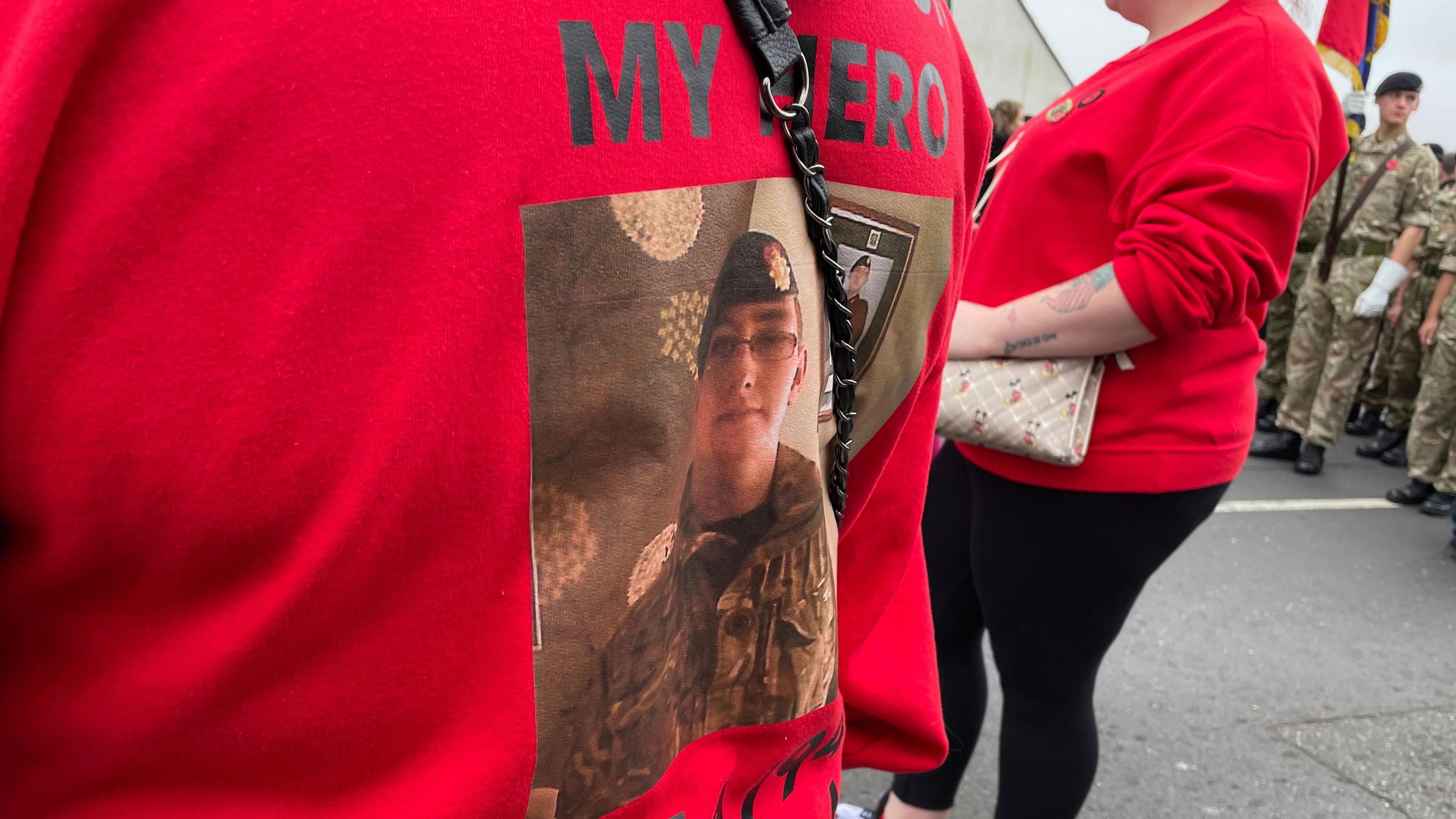 Woman wearing a jumper to remember the fallen at a Remembrance Service in Bulwell, Nottinghamshire