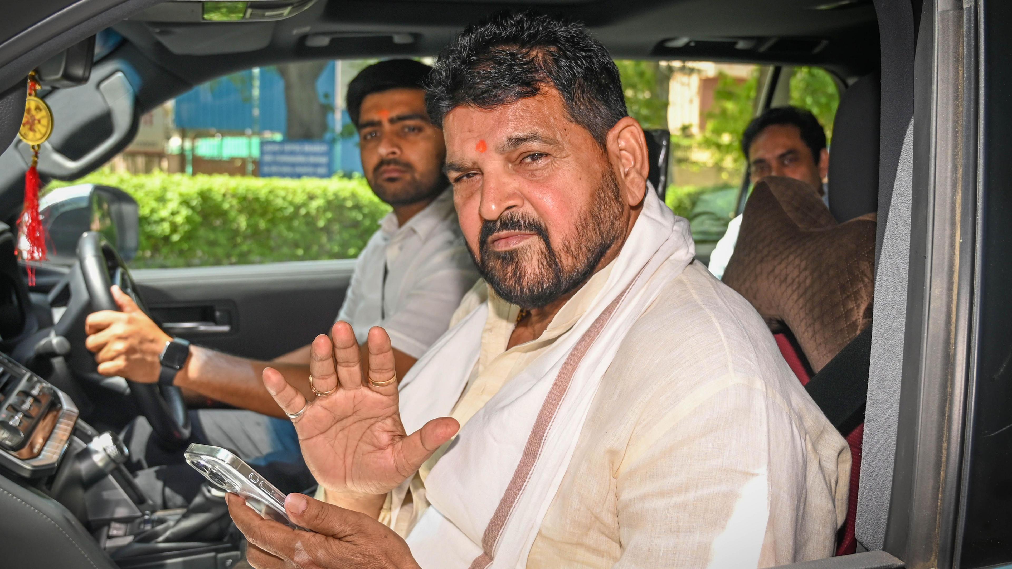 Brij Bhushan Sharan Singh seen in a car as he leaves a court in Delhi after appearing in an alleged sexual harassment case on 18 April 2024. He's sitting next to the driver, wearing a white kurta.