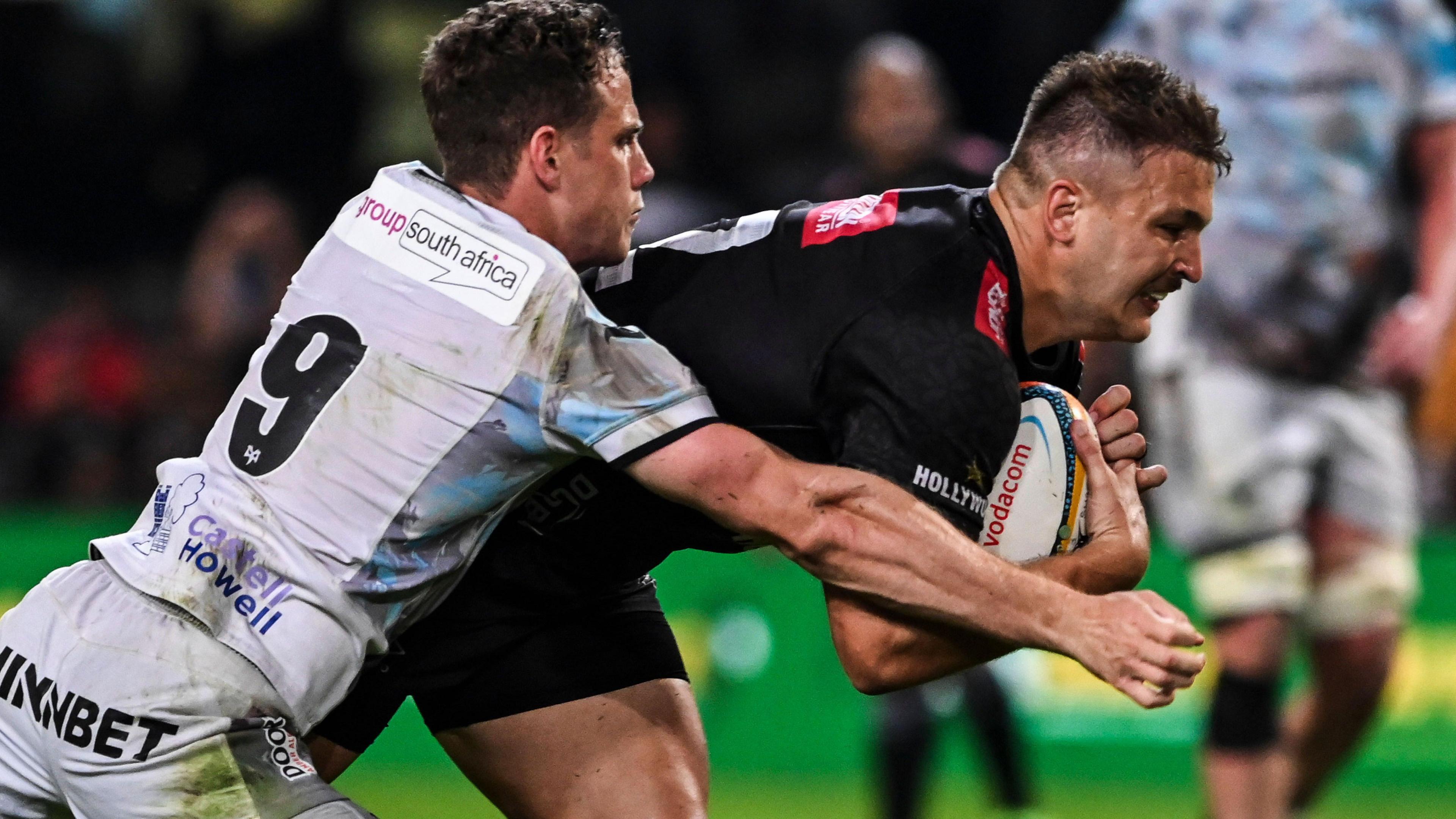 Andre Esterhuizen of Hollywoodbets Sharks scores a try despite Kieran Hardy of Ospreys