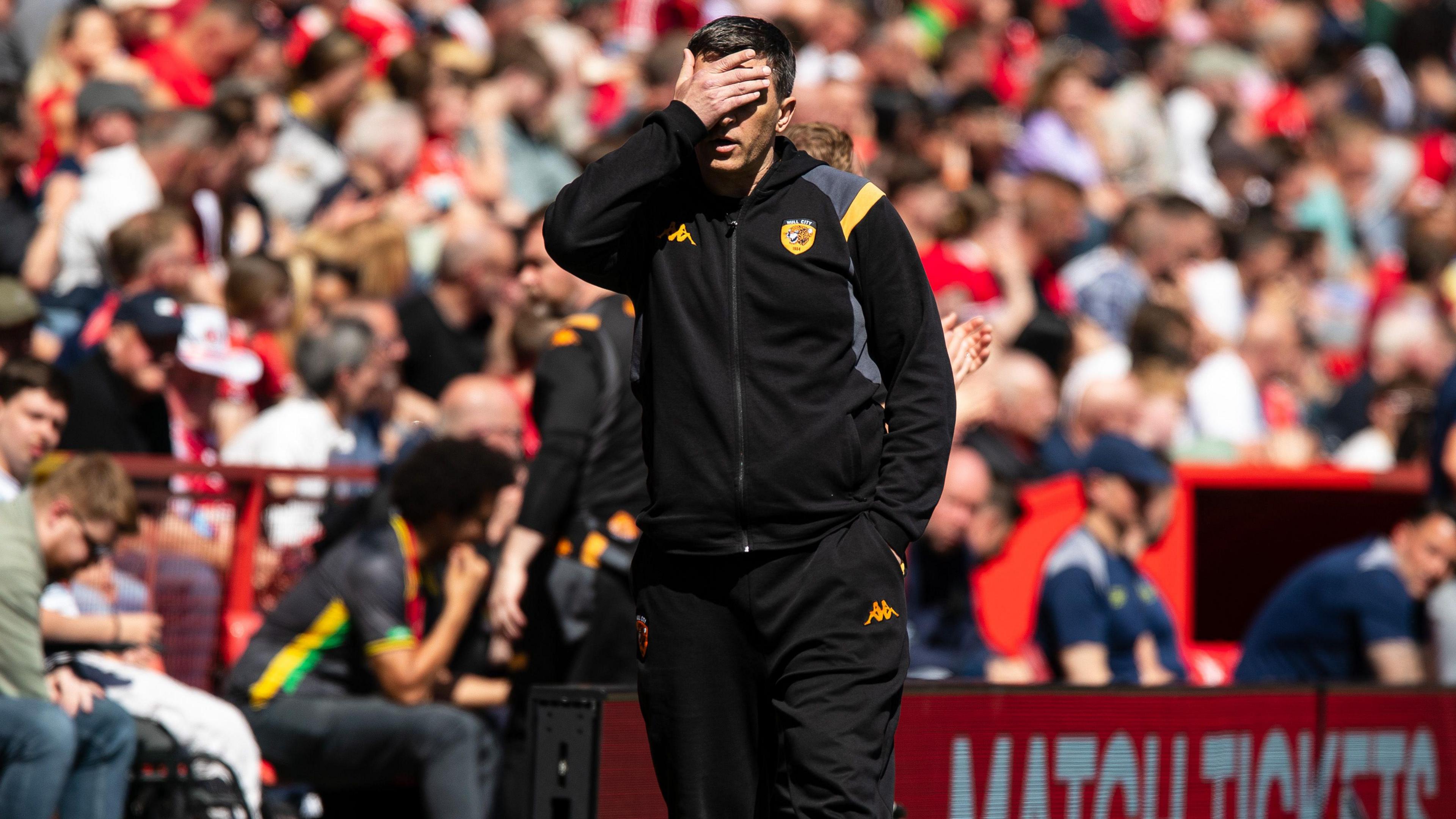 Sergej Jakirovic puts his hand over his eyes as he walks along the touchline